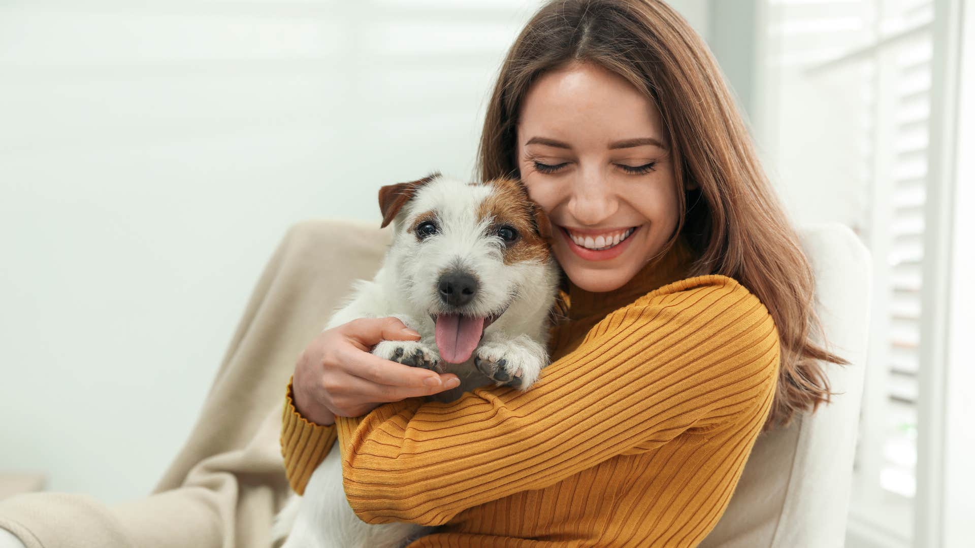 Woman with pet hair on her clothes hugging her dog.