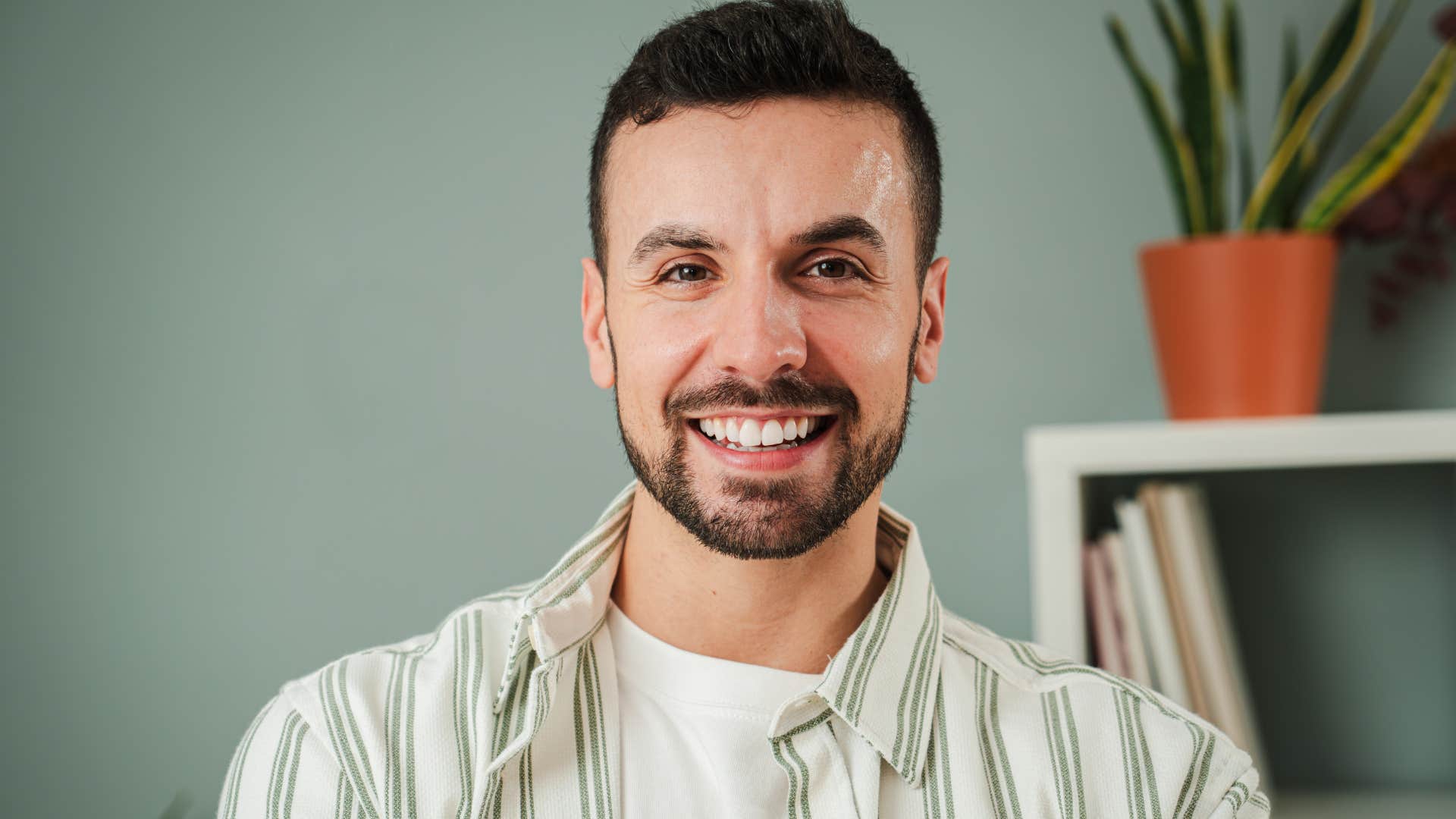 Man who doesn't chase love smiling at the camera.