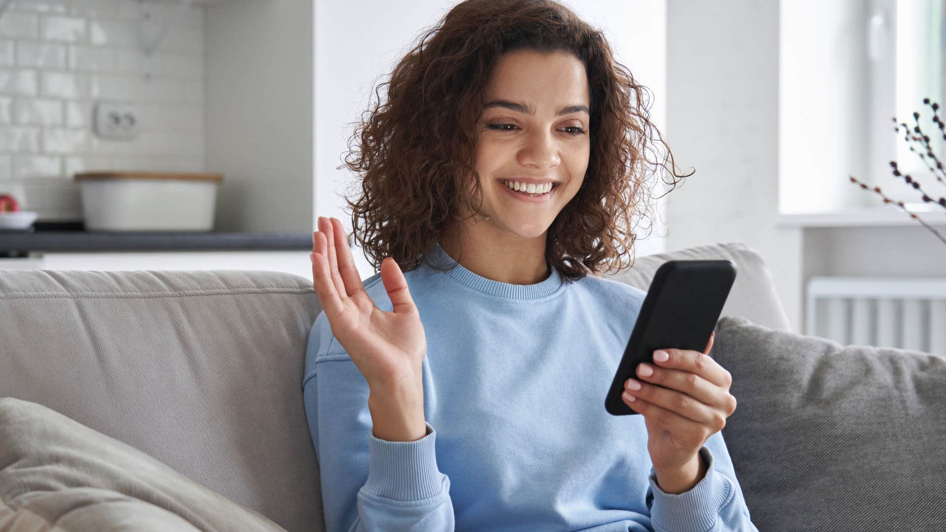 Woman who can talk to parents like friends smiling on the phone.