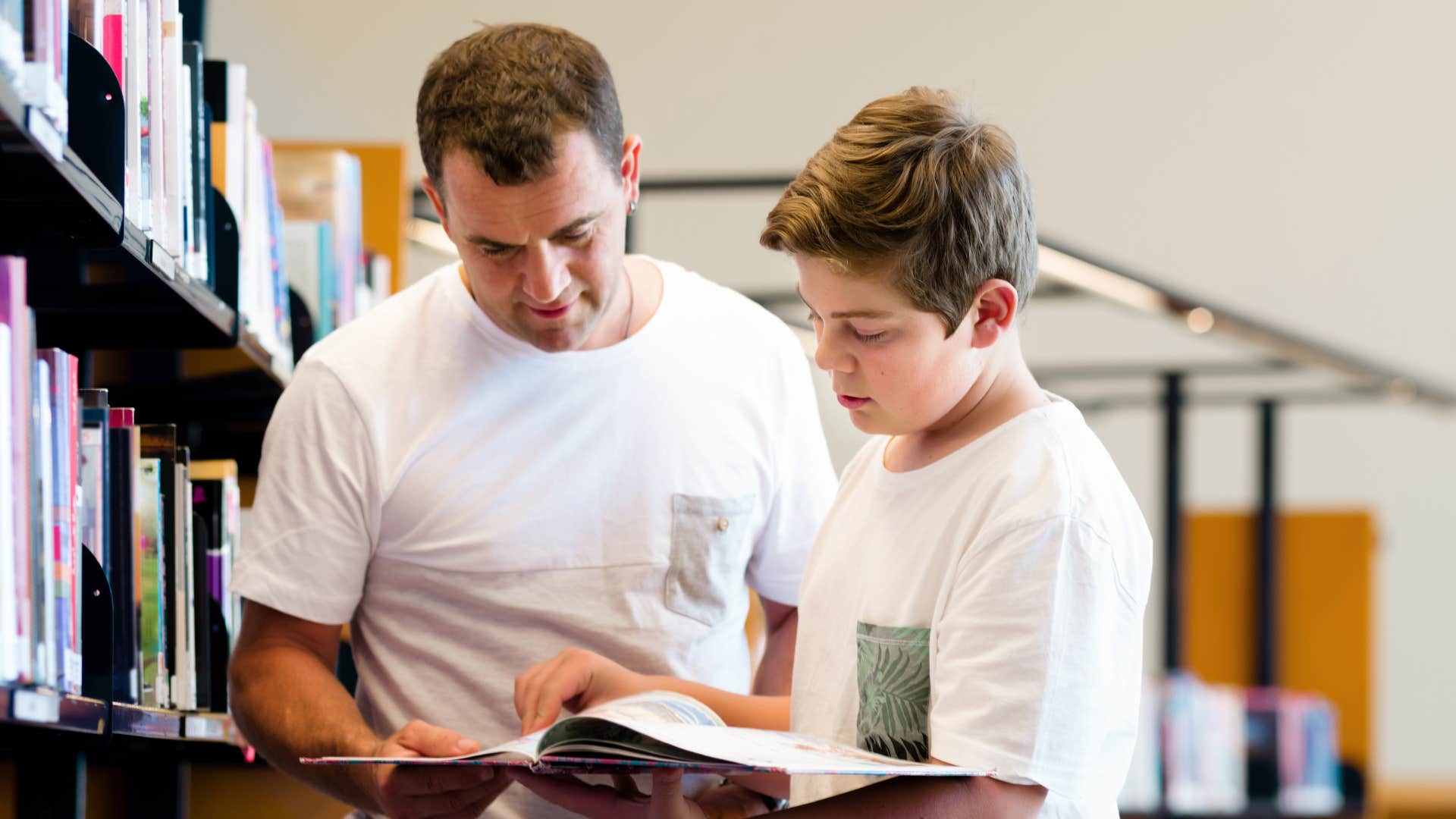a father takes his son to the local library to check out books
