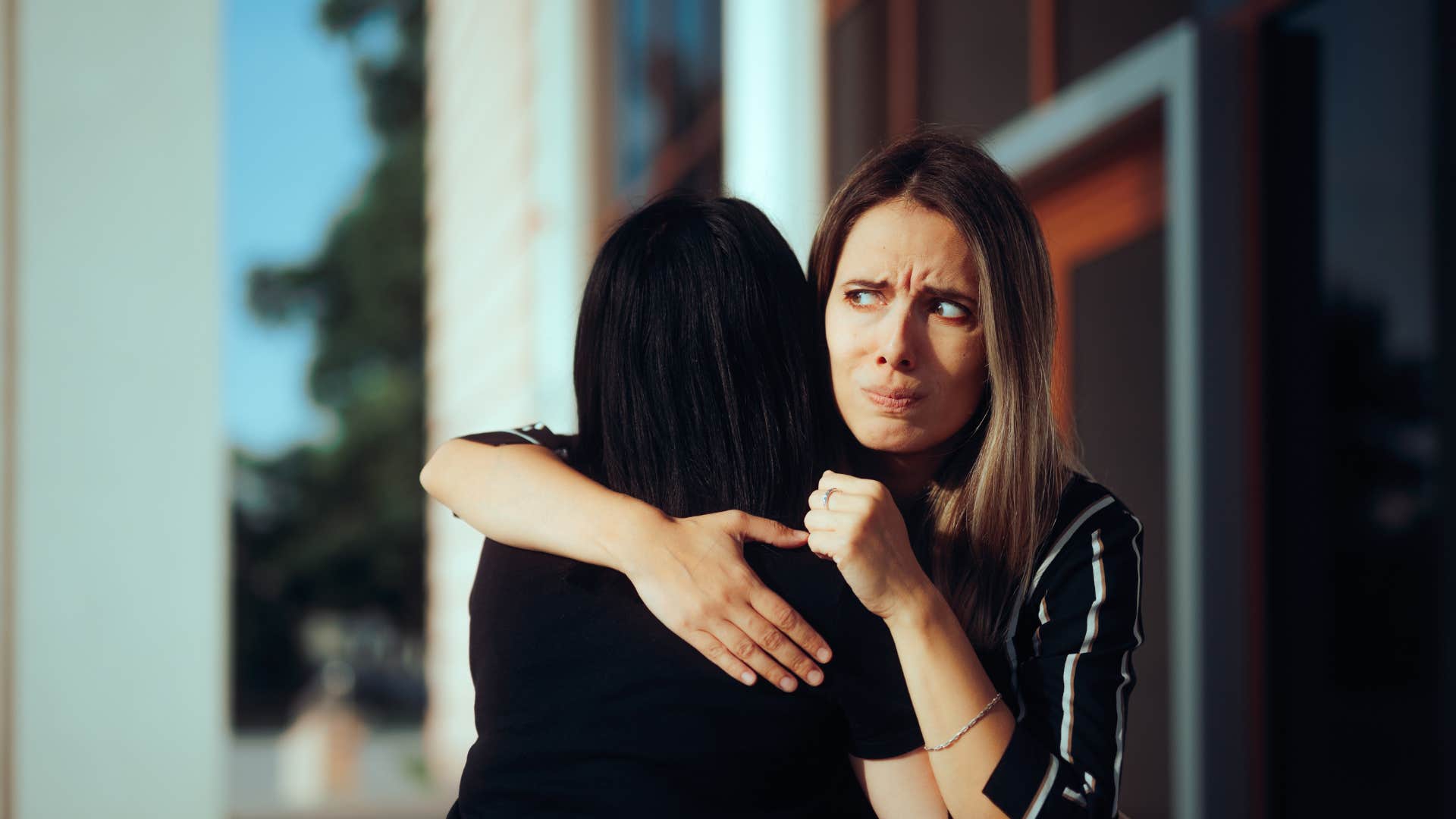 judgmental woman hugging friend saying she could never live like that