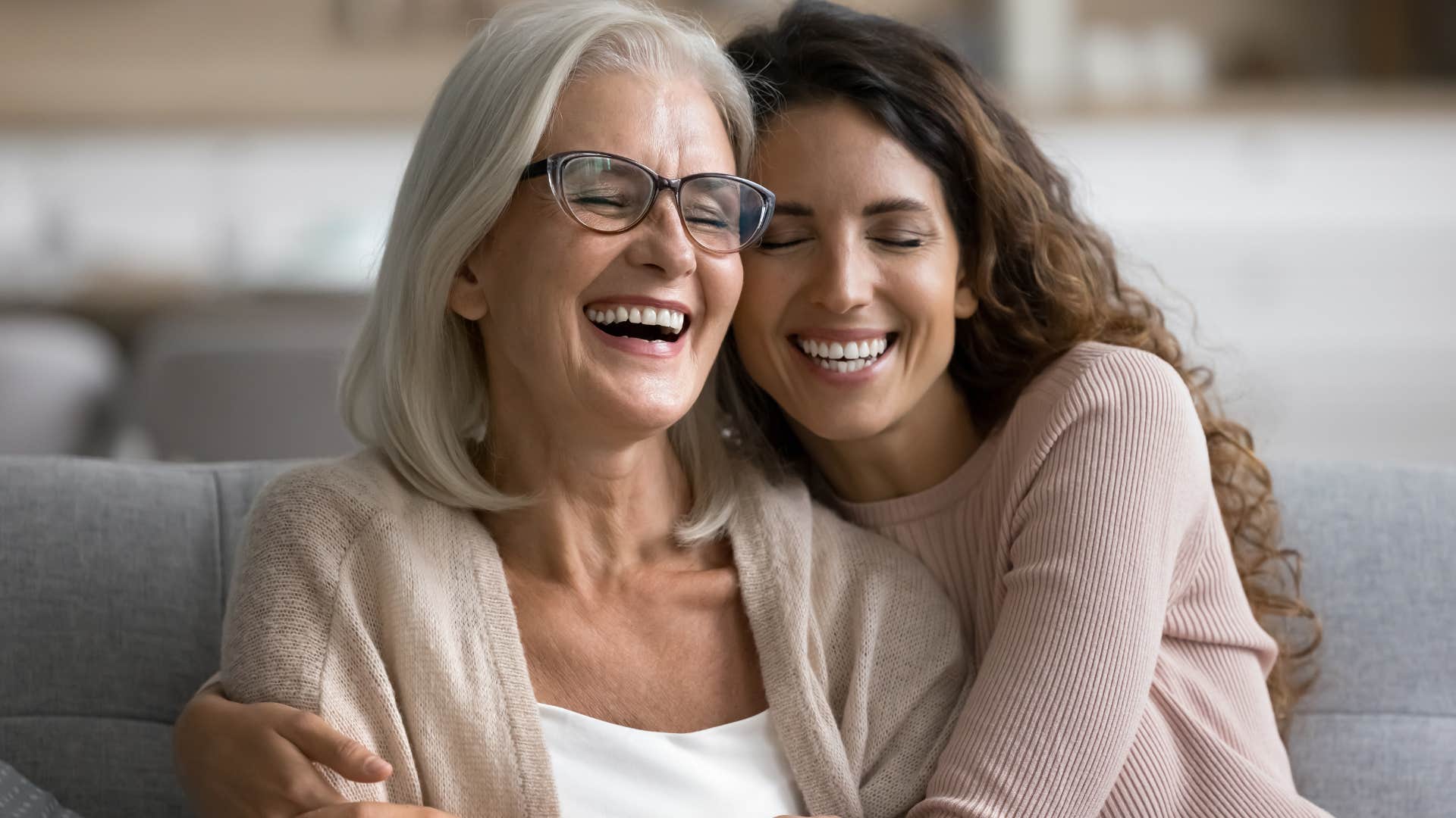Woman who's close with their parents hugging on the couch.