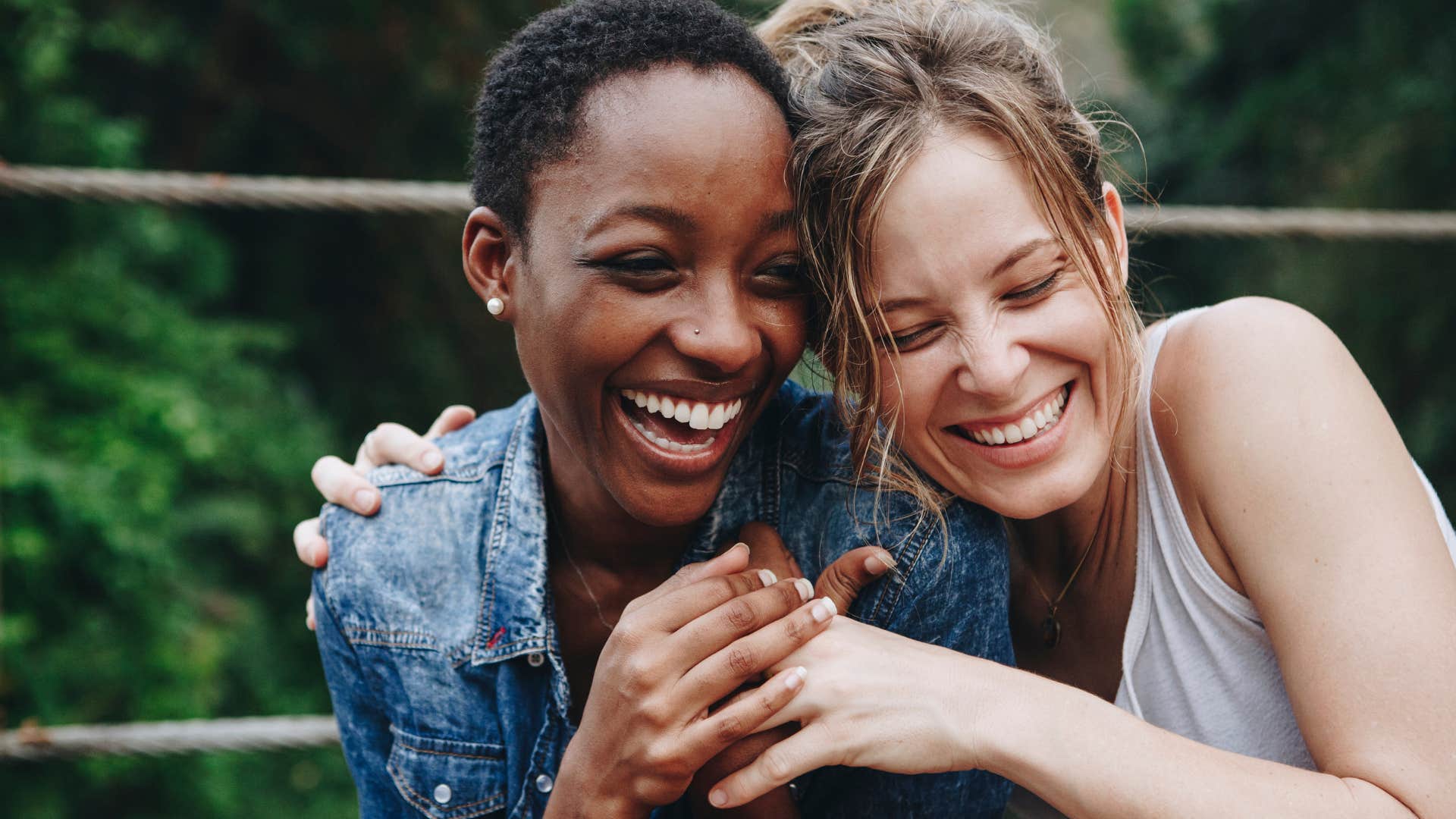 Empathetic woman smiling and hugging her friend.