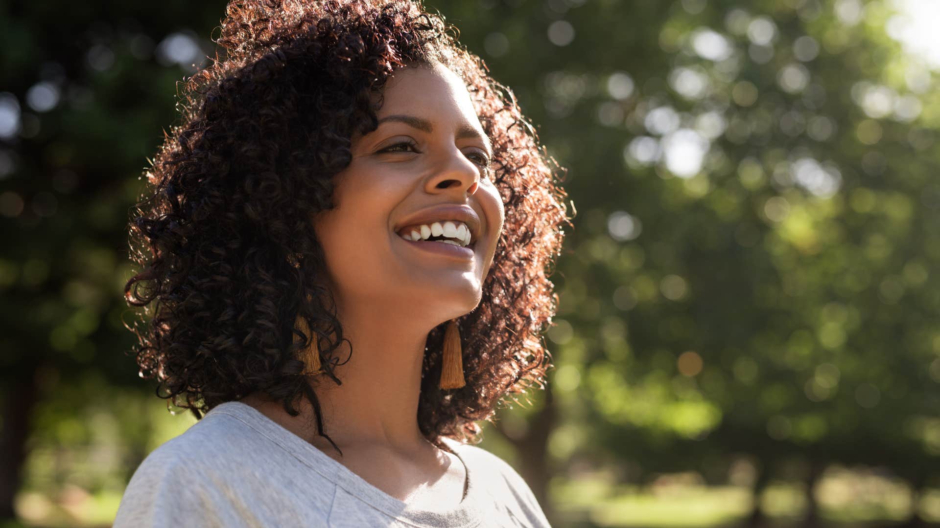 Independent woman smiling outside.