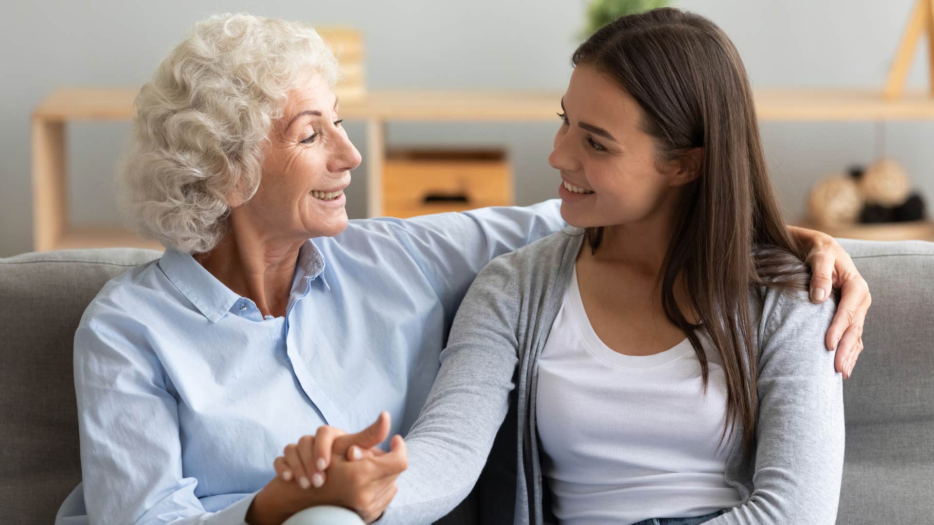 older woman with blue shirt telling women in white shirt you're so brave while side hugging her