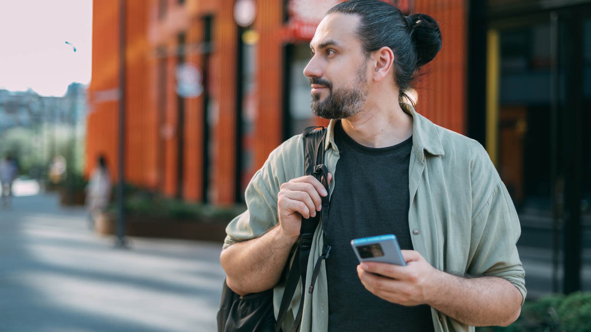 Man walking around on their phone outside.