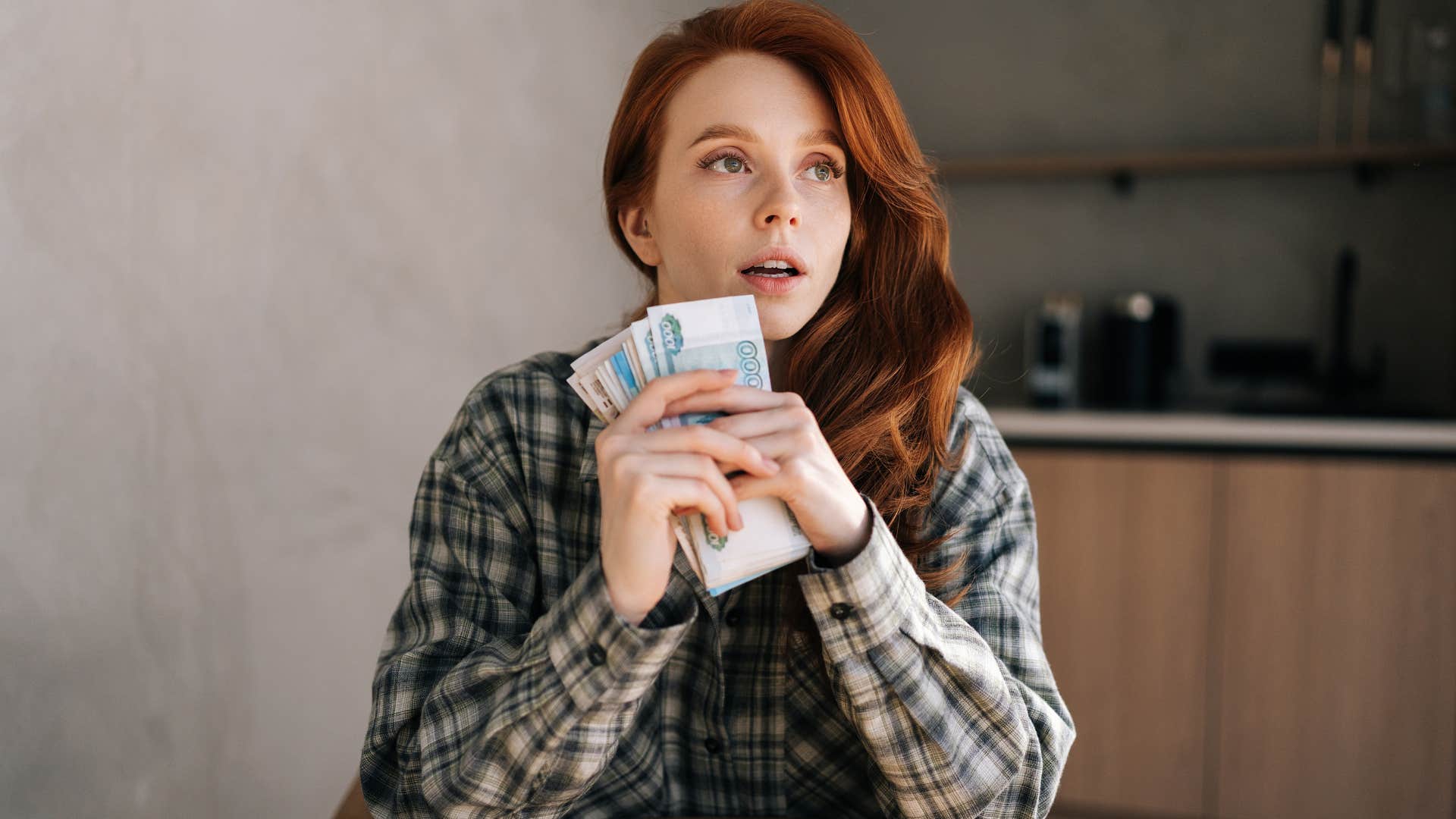 woman holding money close to her face