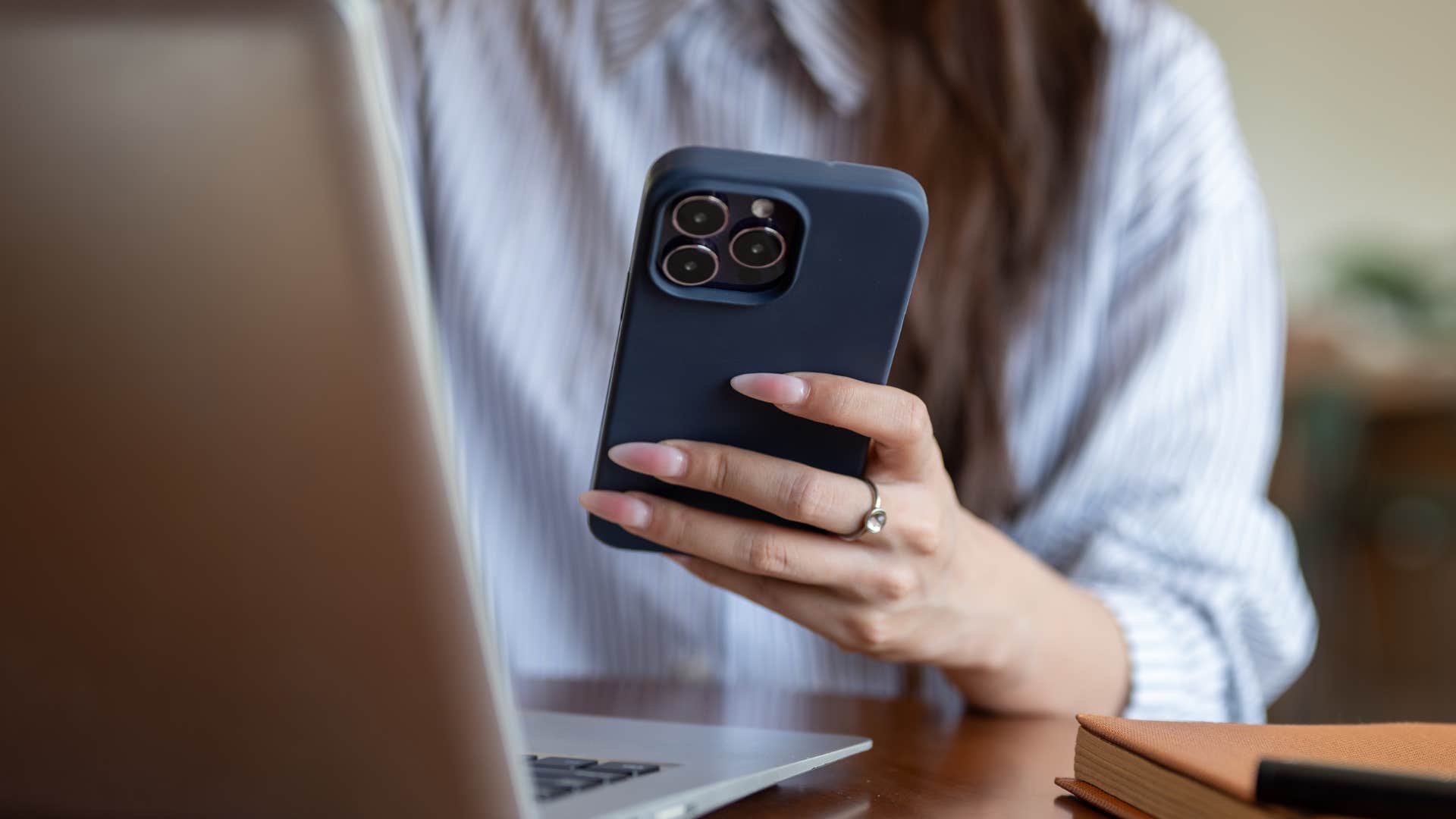 woman texting on her phone with long nails