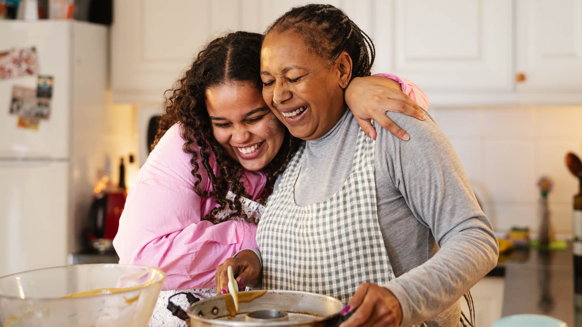 Woman hugging her granddaughter and stretching meals in the kitchen.