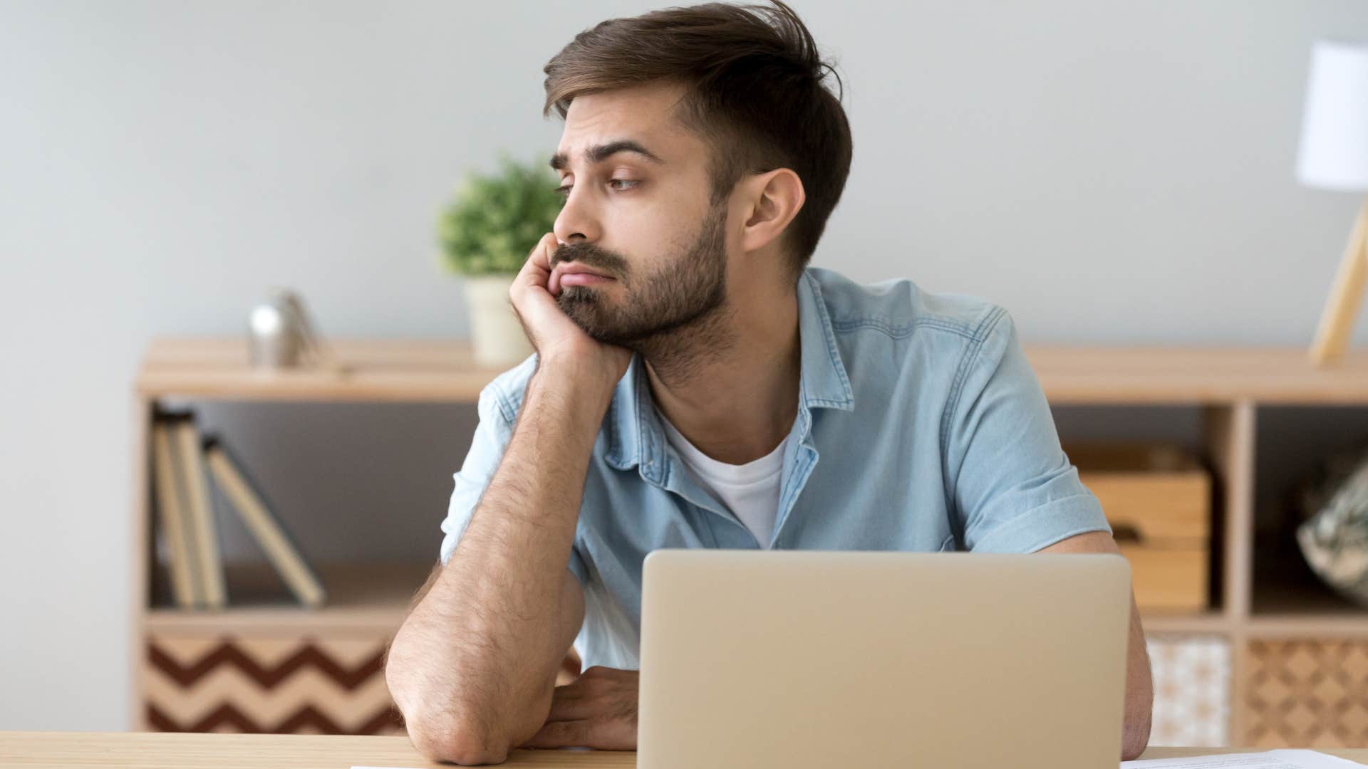 Man thinking about laziness at his work desk.