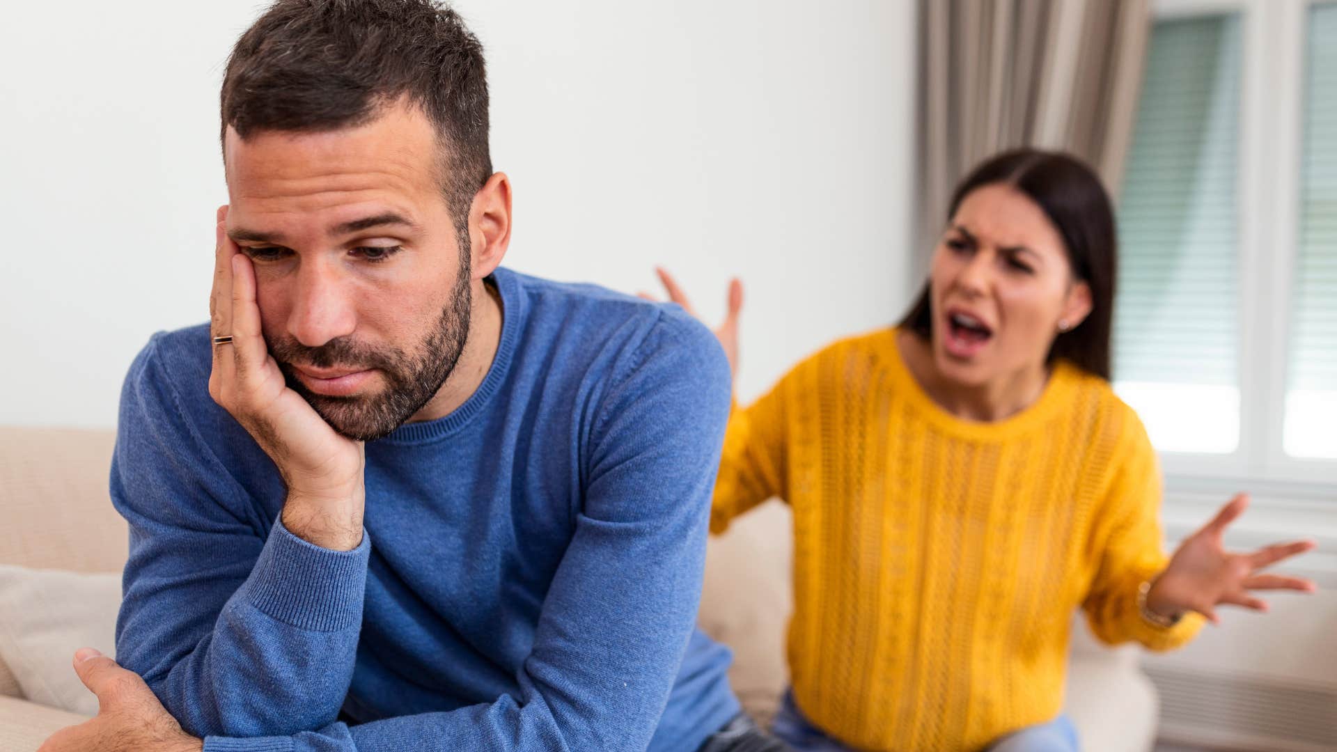 man lying in front of his upset partner