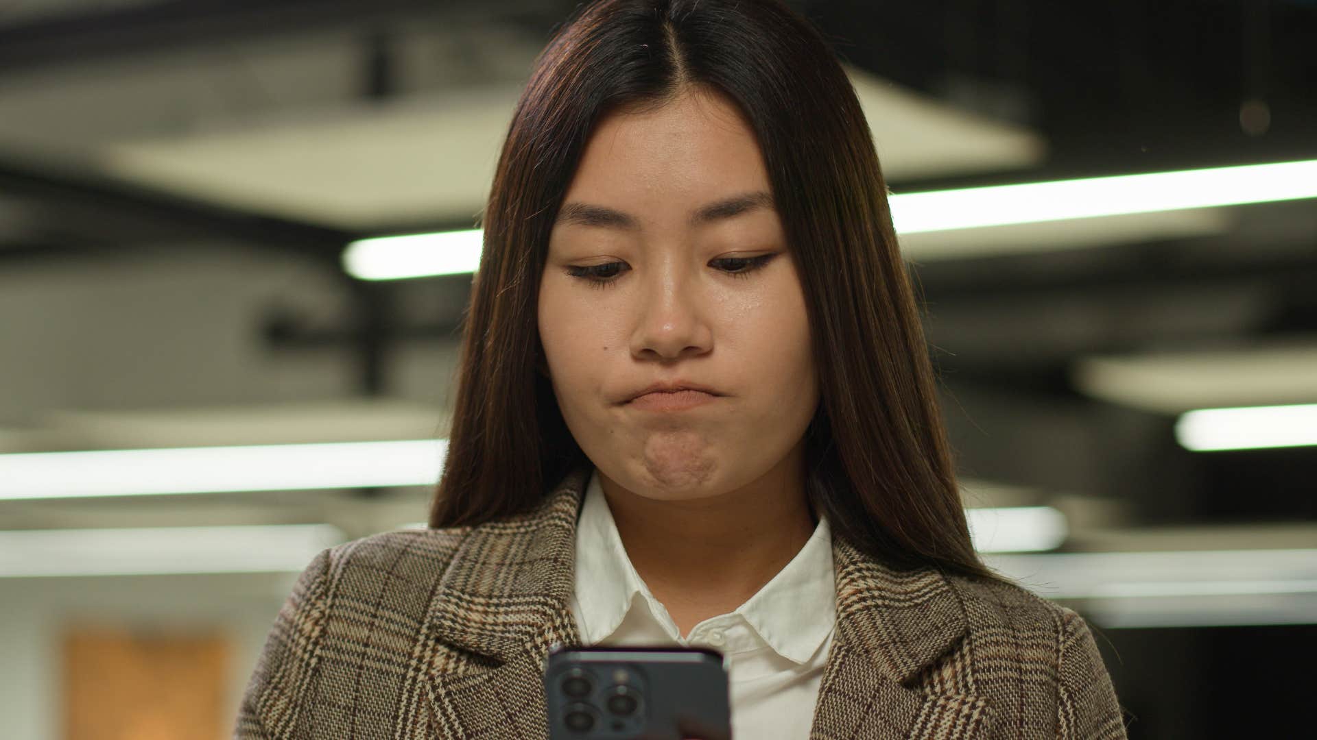 woman who uses her money to intimidate looking at her phone