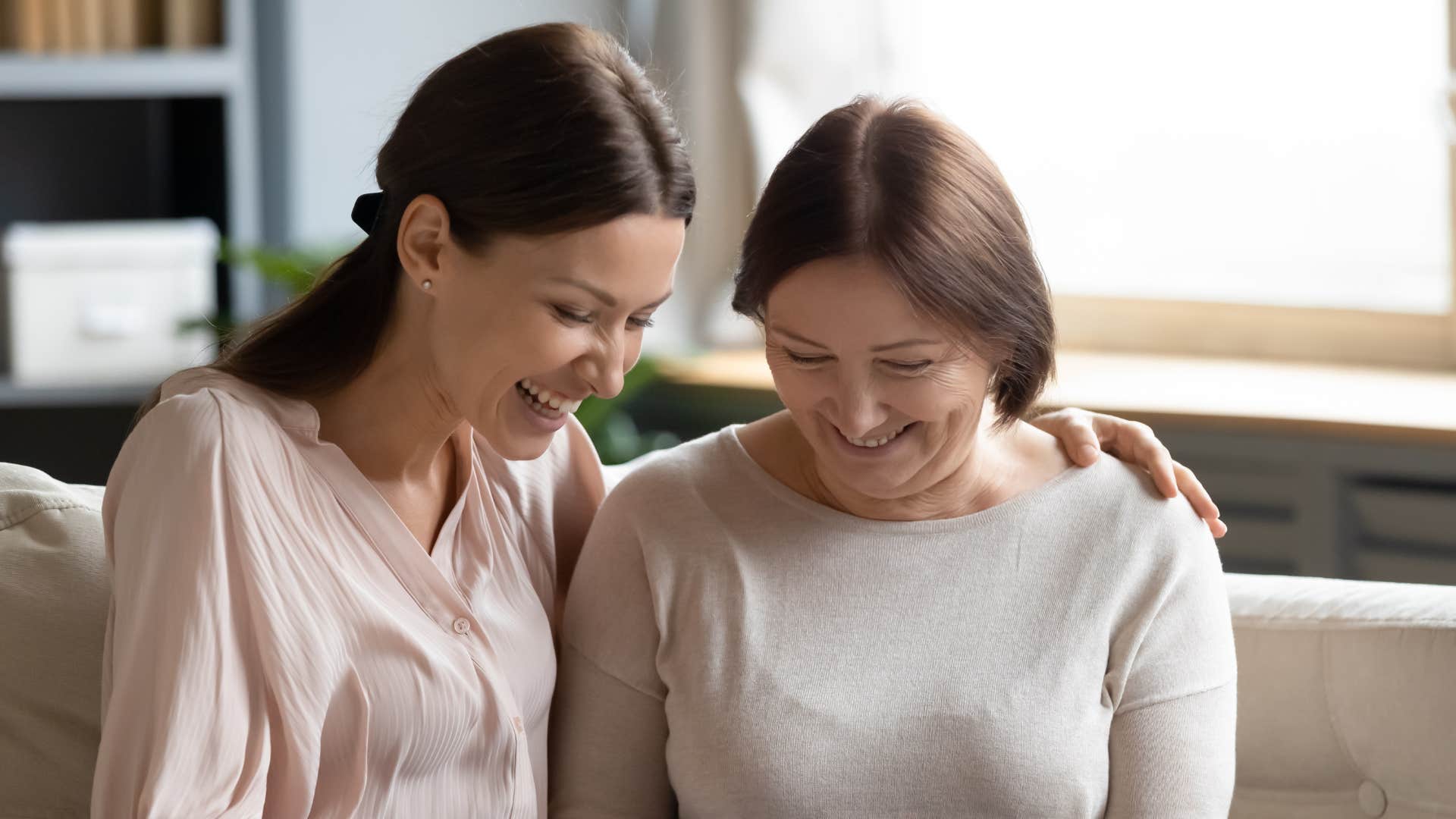 a grandmother shows her daughter the printed photos she has of her grandkids 