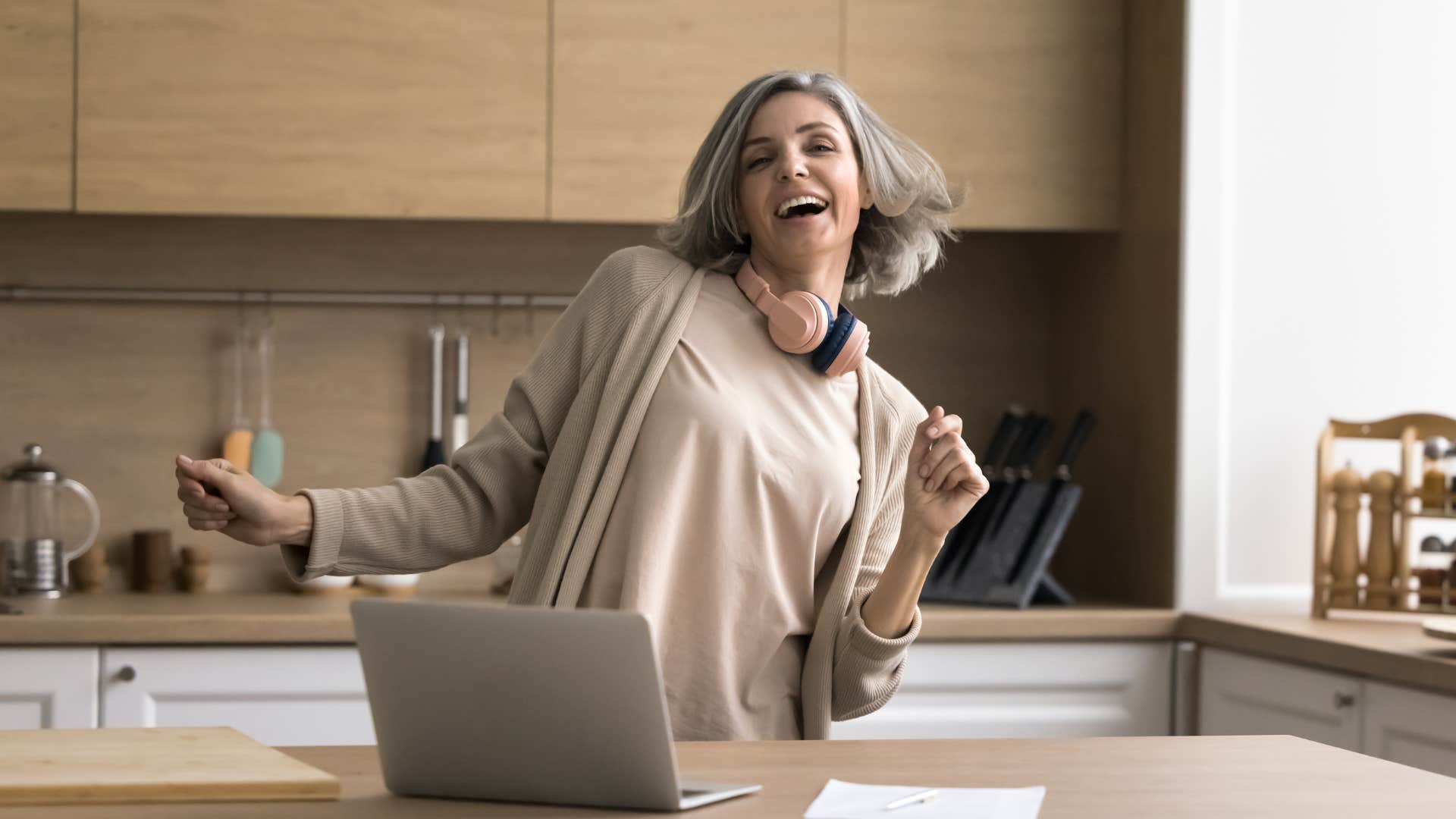gen x woman listening to her old song recordings on laptop