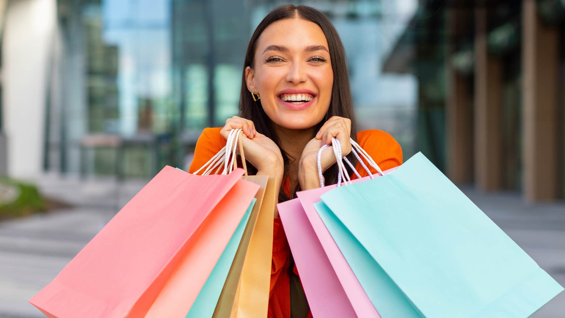 gen x woman smiling big with lots of shopping bags