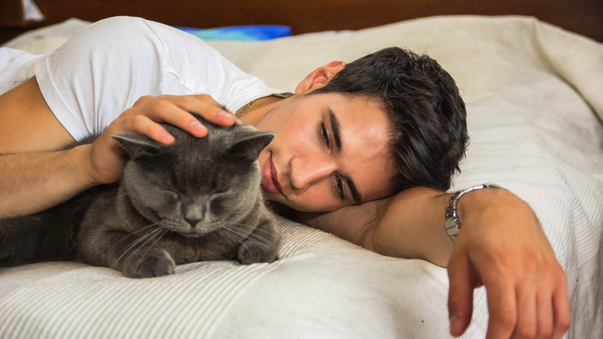 teenage boy rubbing his cats head