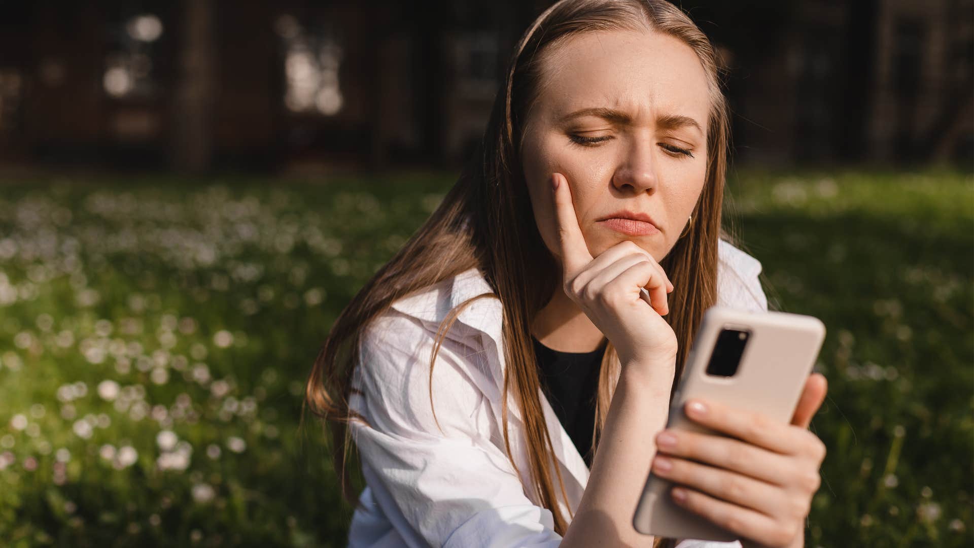 Upset woman curating success on social media on her phone.