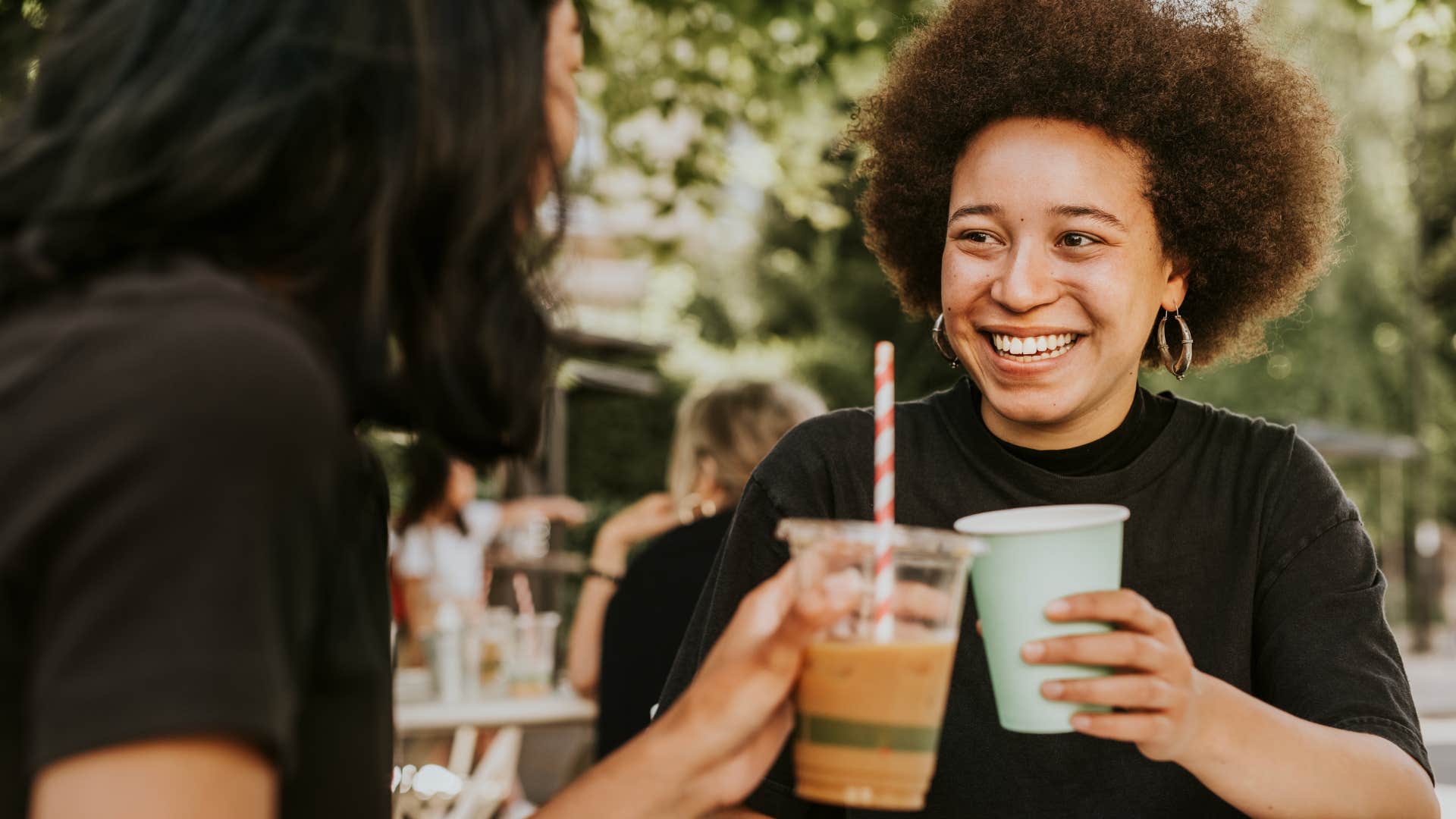 Woman smiling and drinking expensive coffee with her friend.