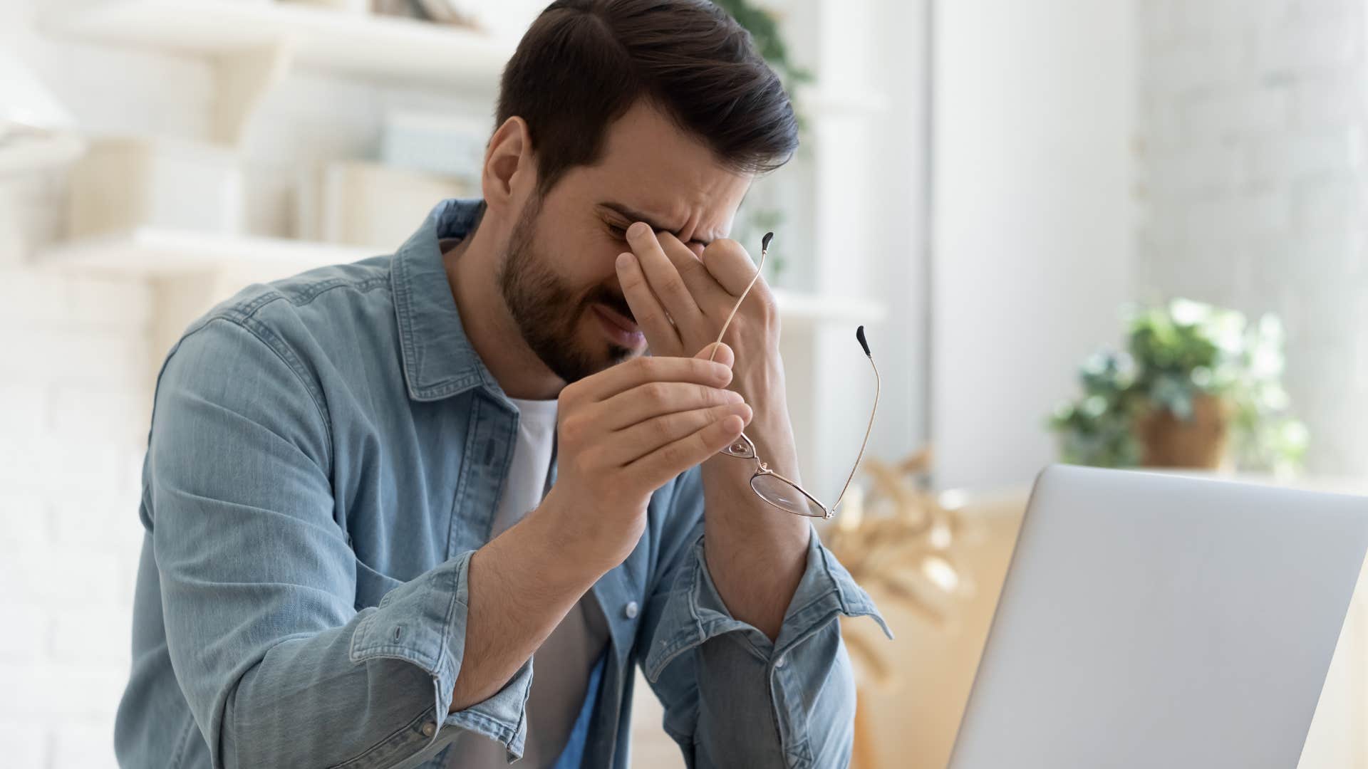Man stressing out at his desk while having a full calendar.