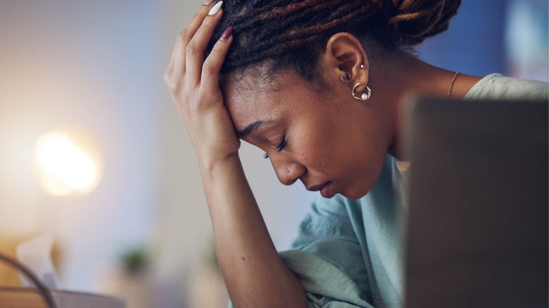Woman holding her head and thinking about wellness trends that feel like work.