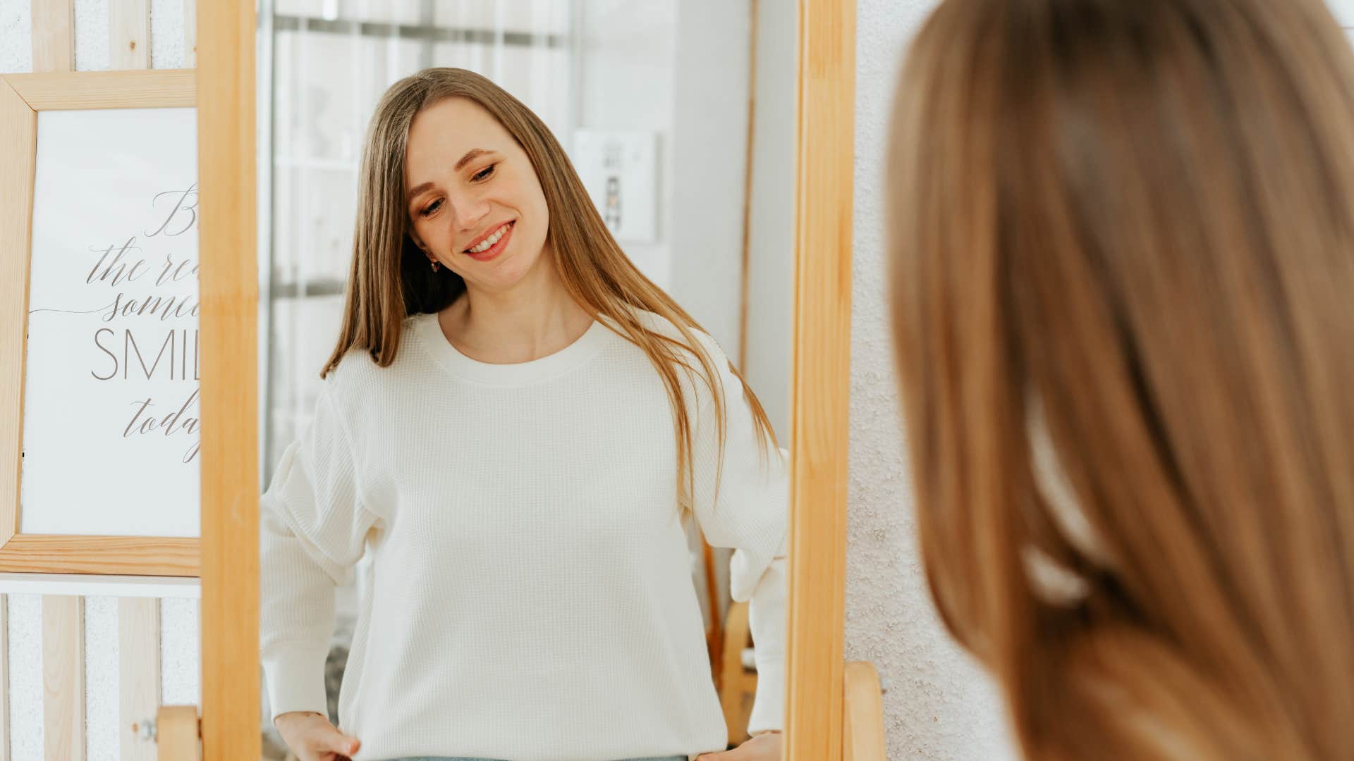 woman smiling looking in mirror positive body image