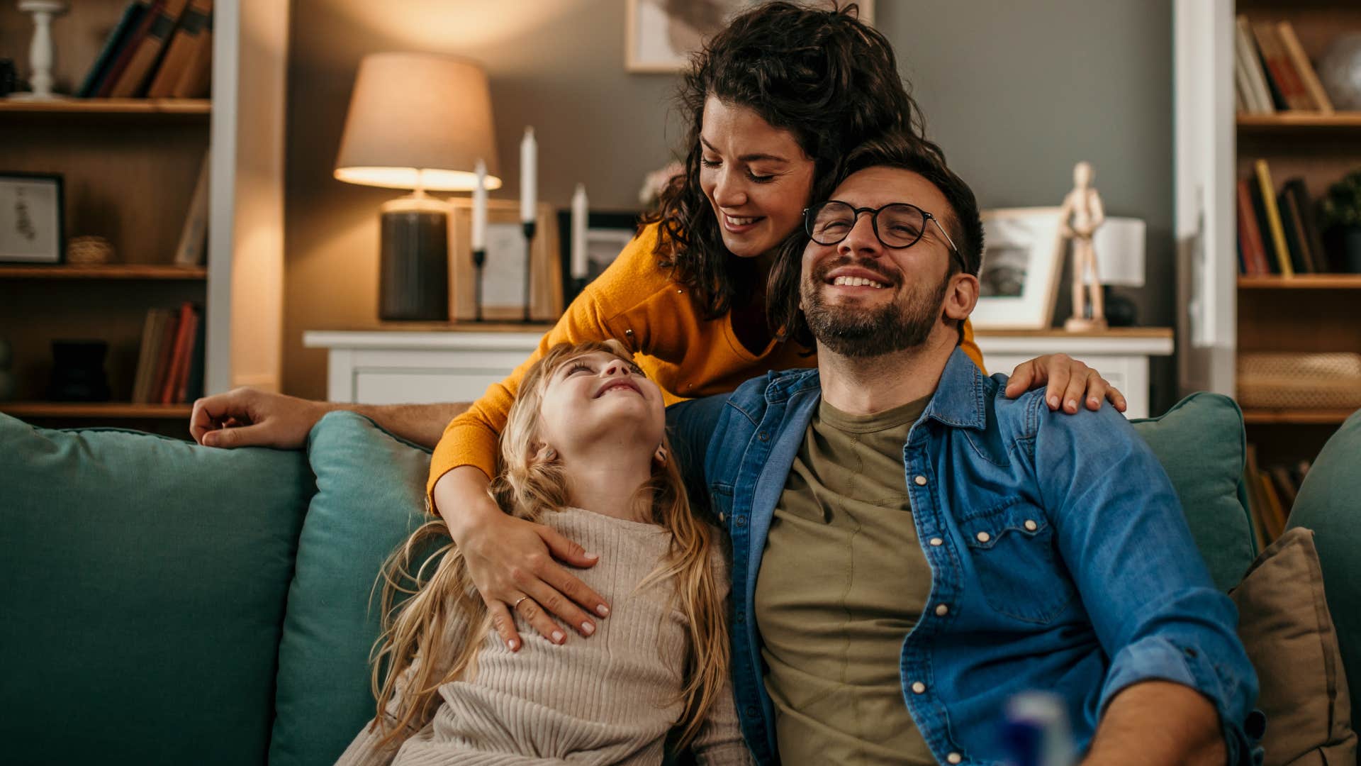 family smiling and hugging in their living room with matching home decor