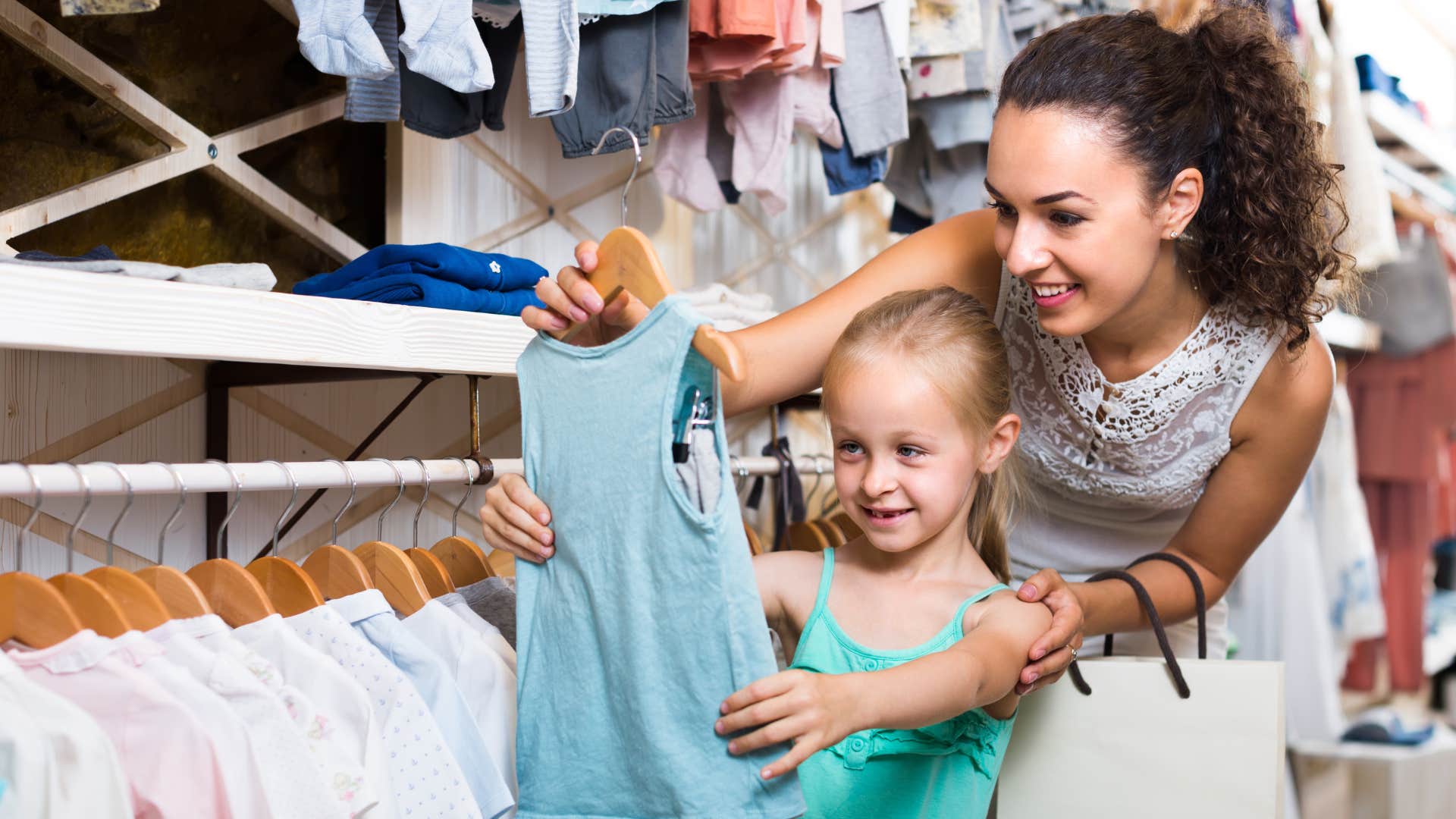 woman picking out new clothes with her daughter