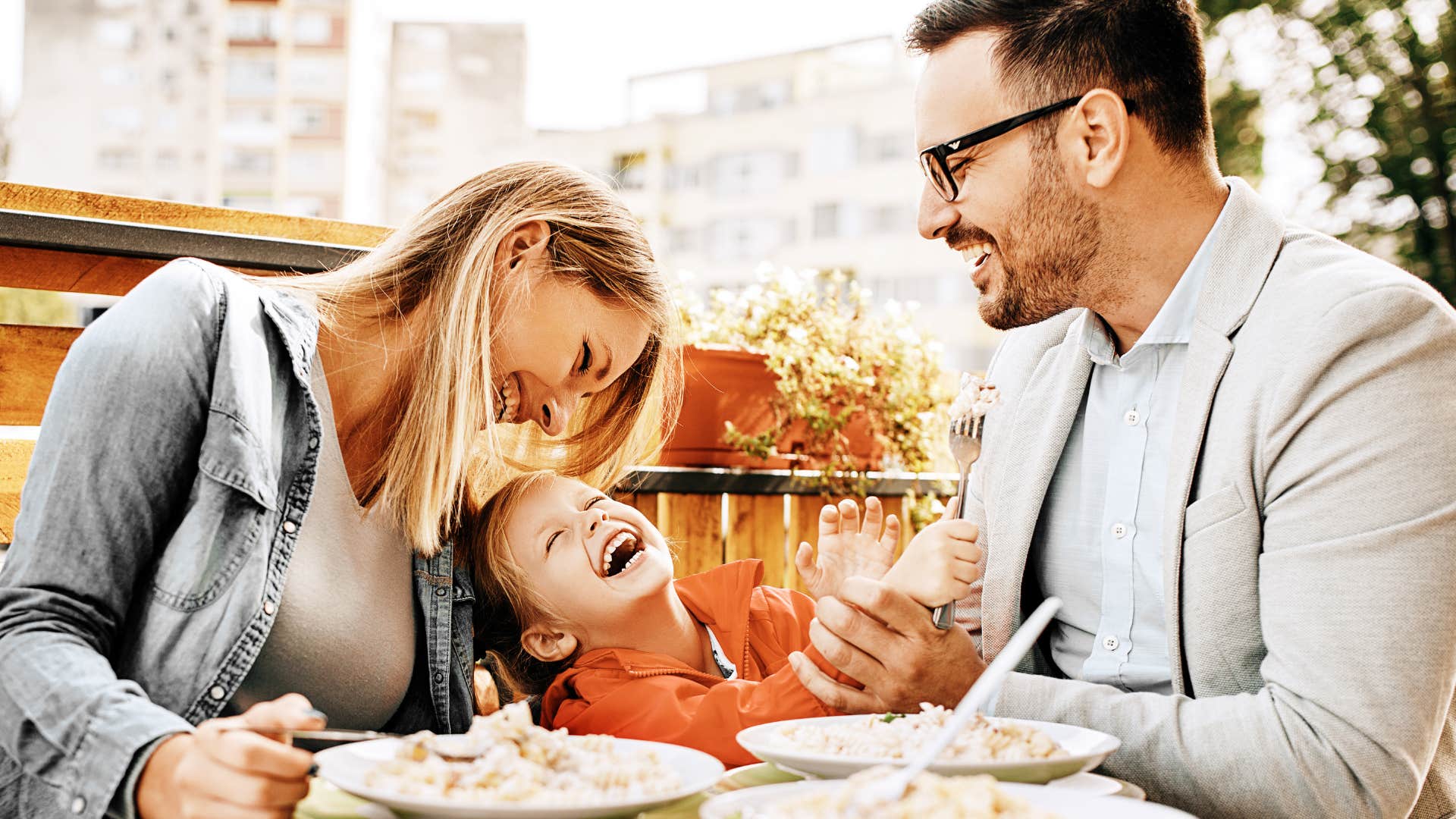young working-class family smiling while out to eat