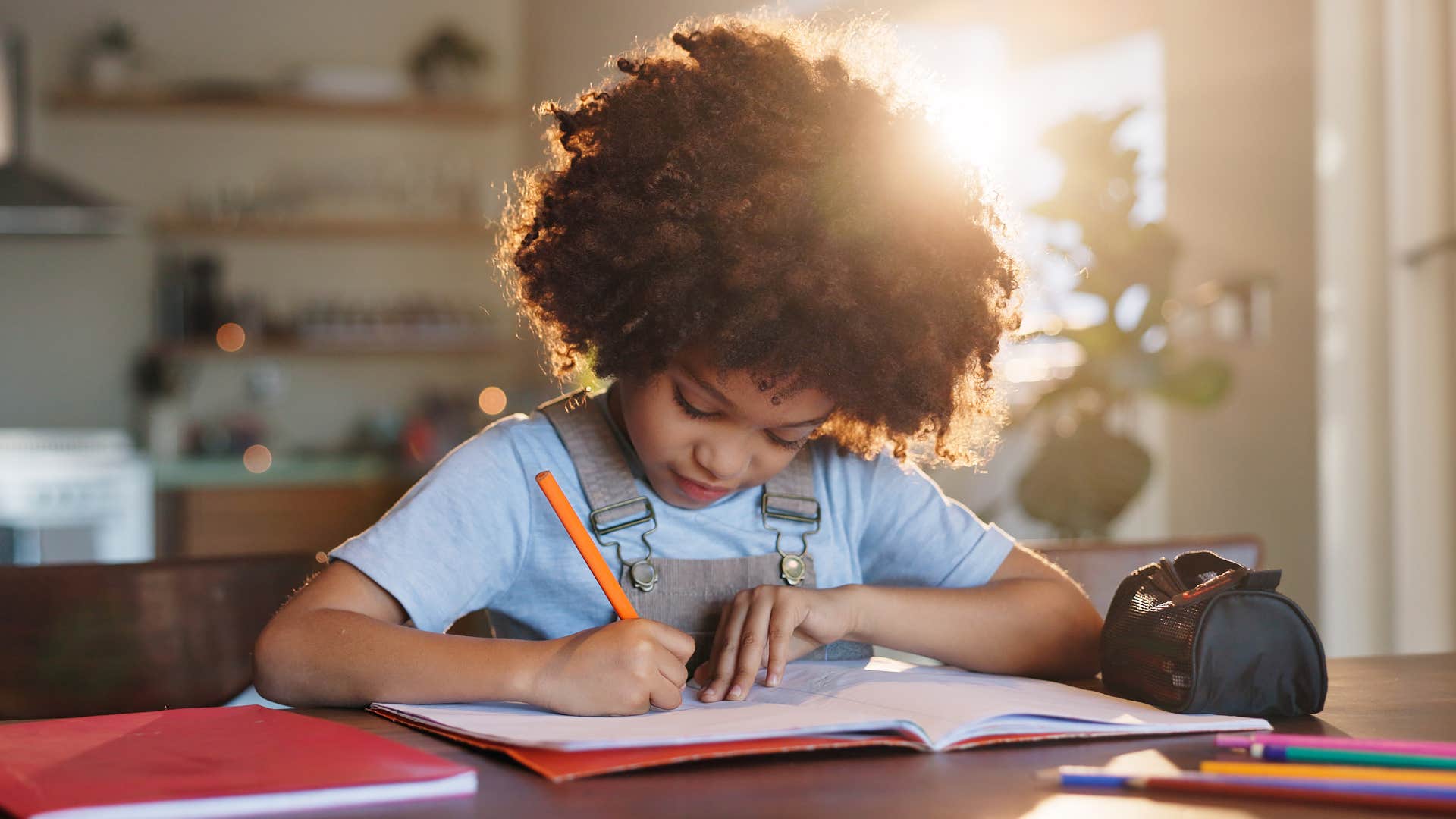 young kid doing homework with brand name school supplies