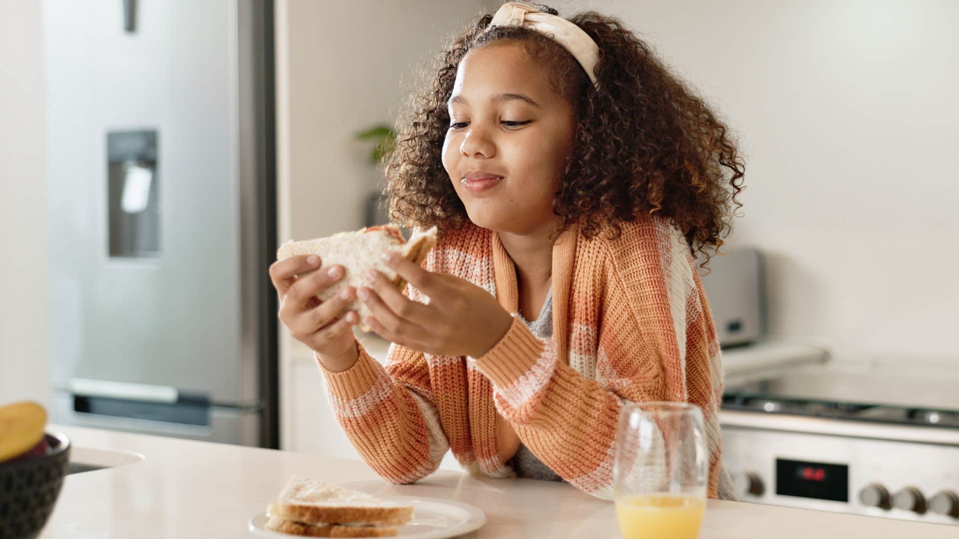 little girl smiling and eating snacks at home