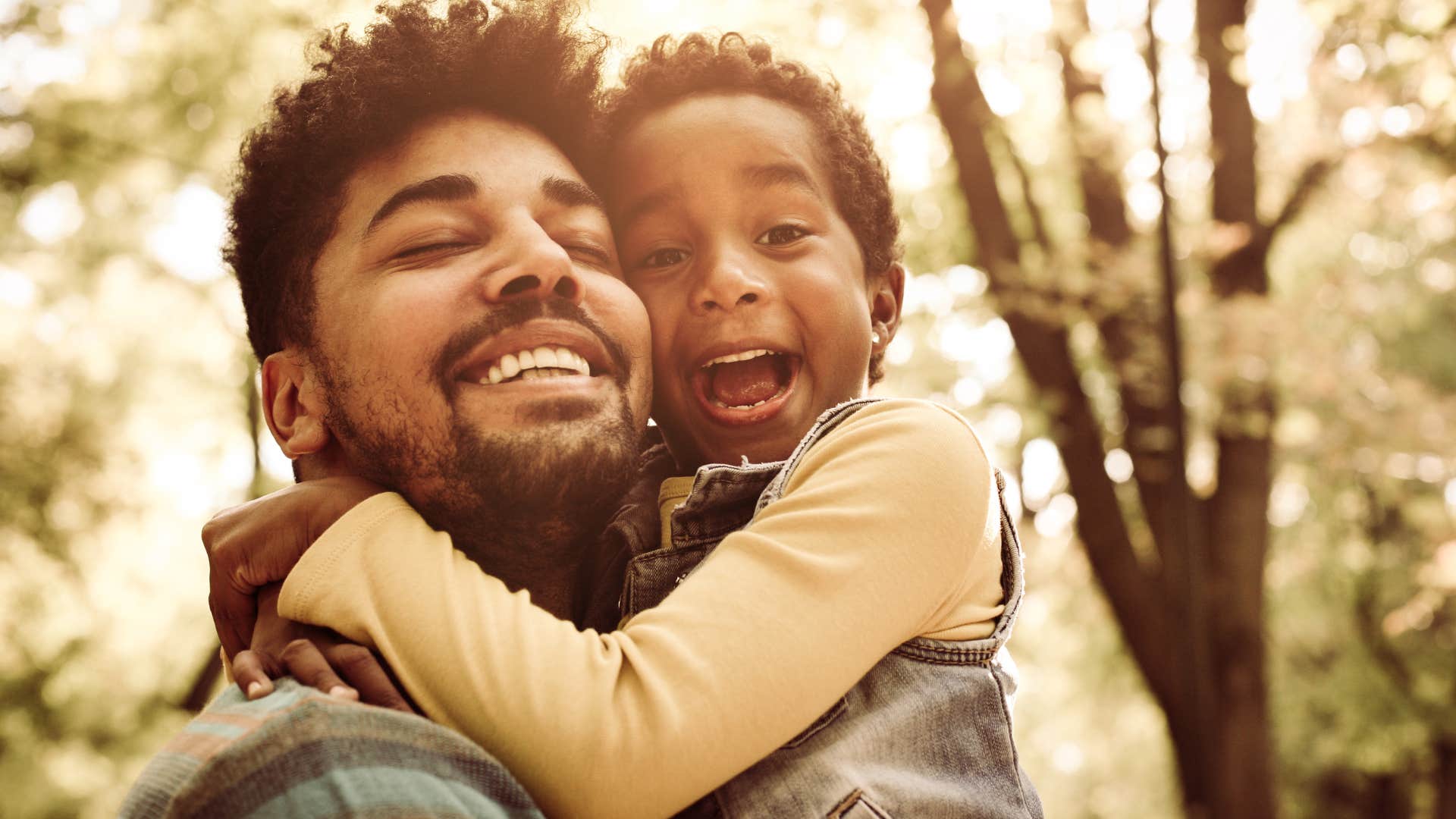 man hugging his young son on vacation