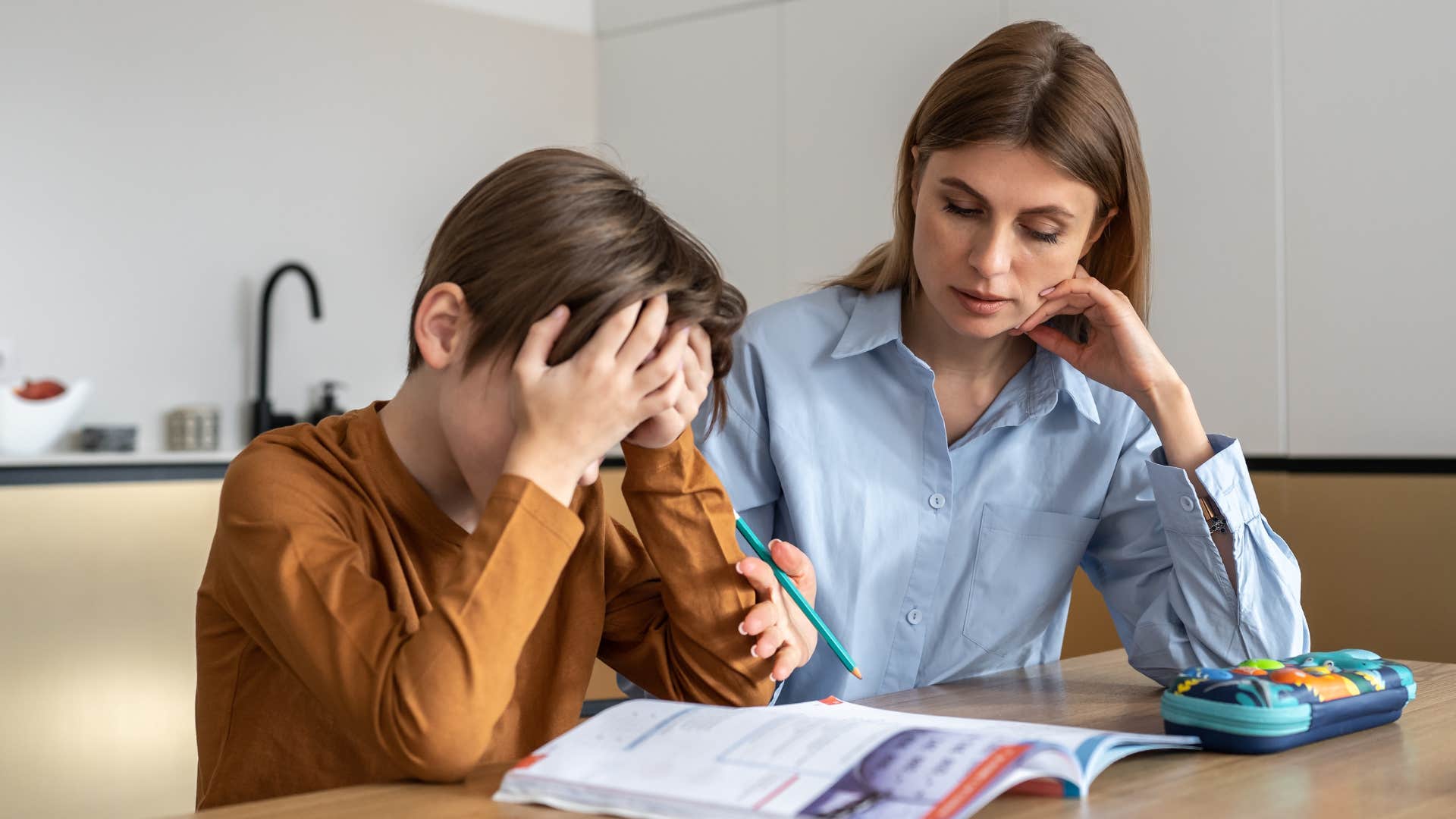 child who's dependent on his parents looking upset doing homework