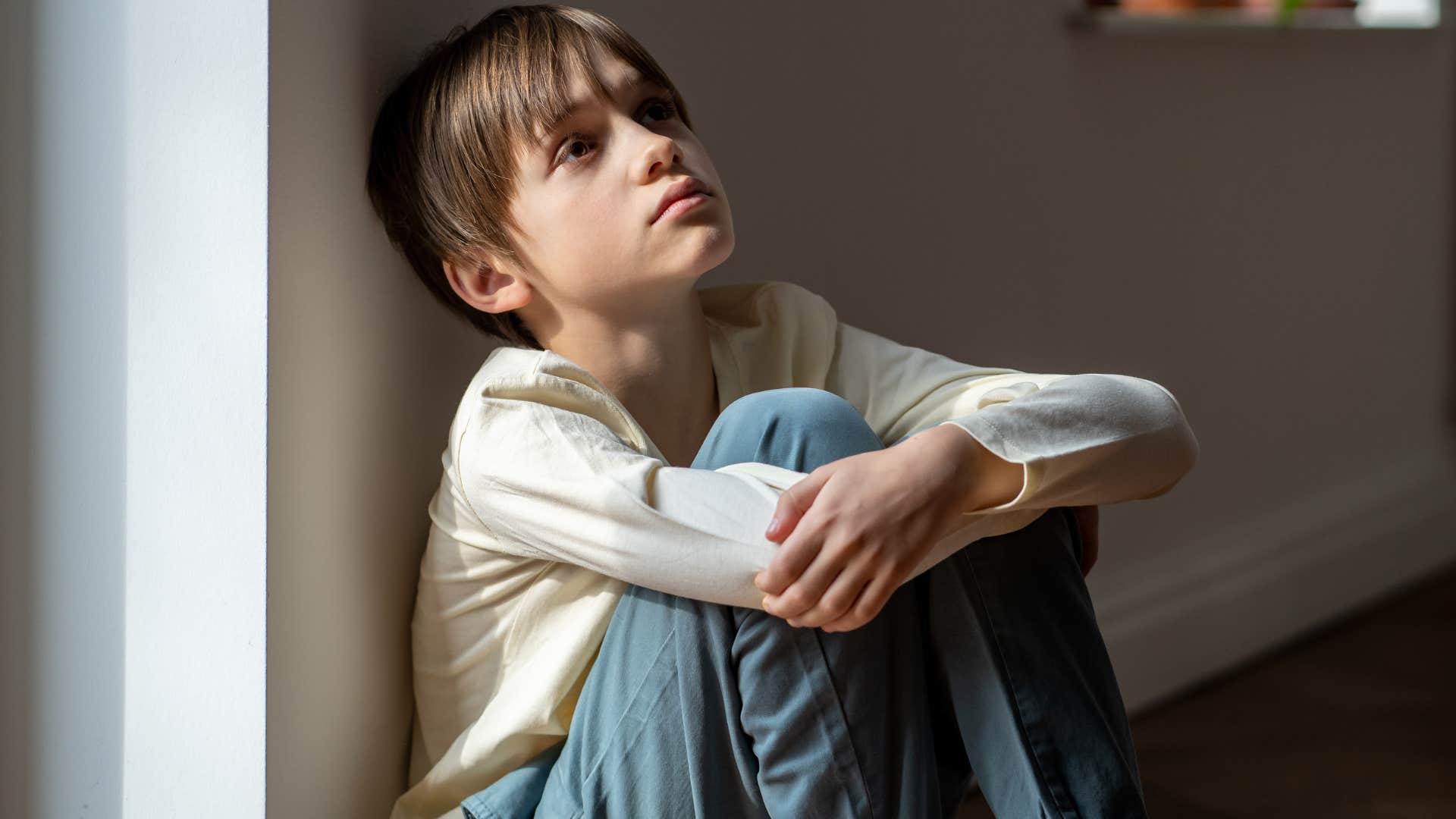 entitled child sitting on the ground at home