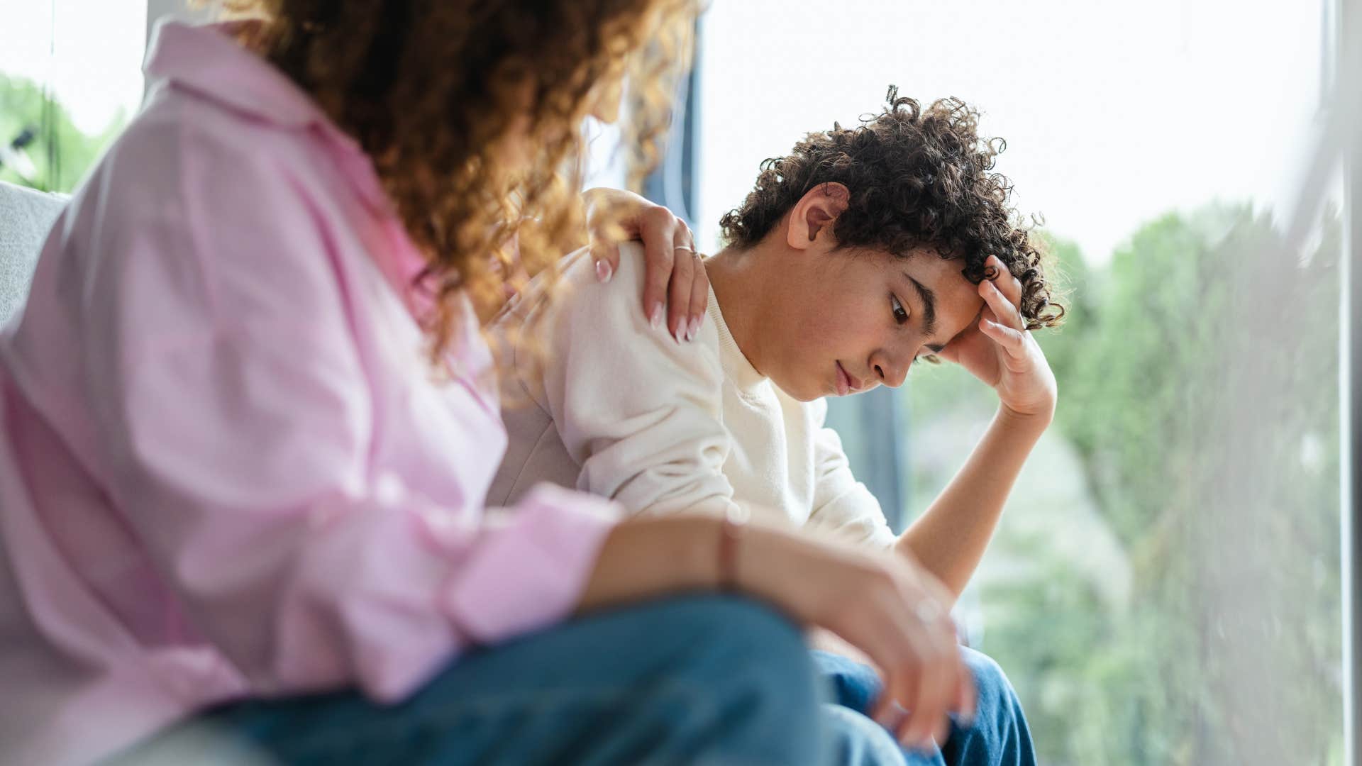 teenage boy who lacks social skills being comforted by his mother