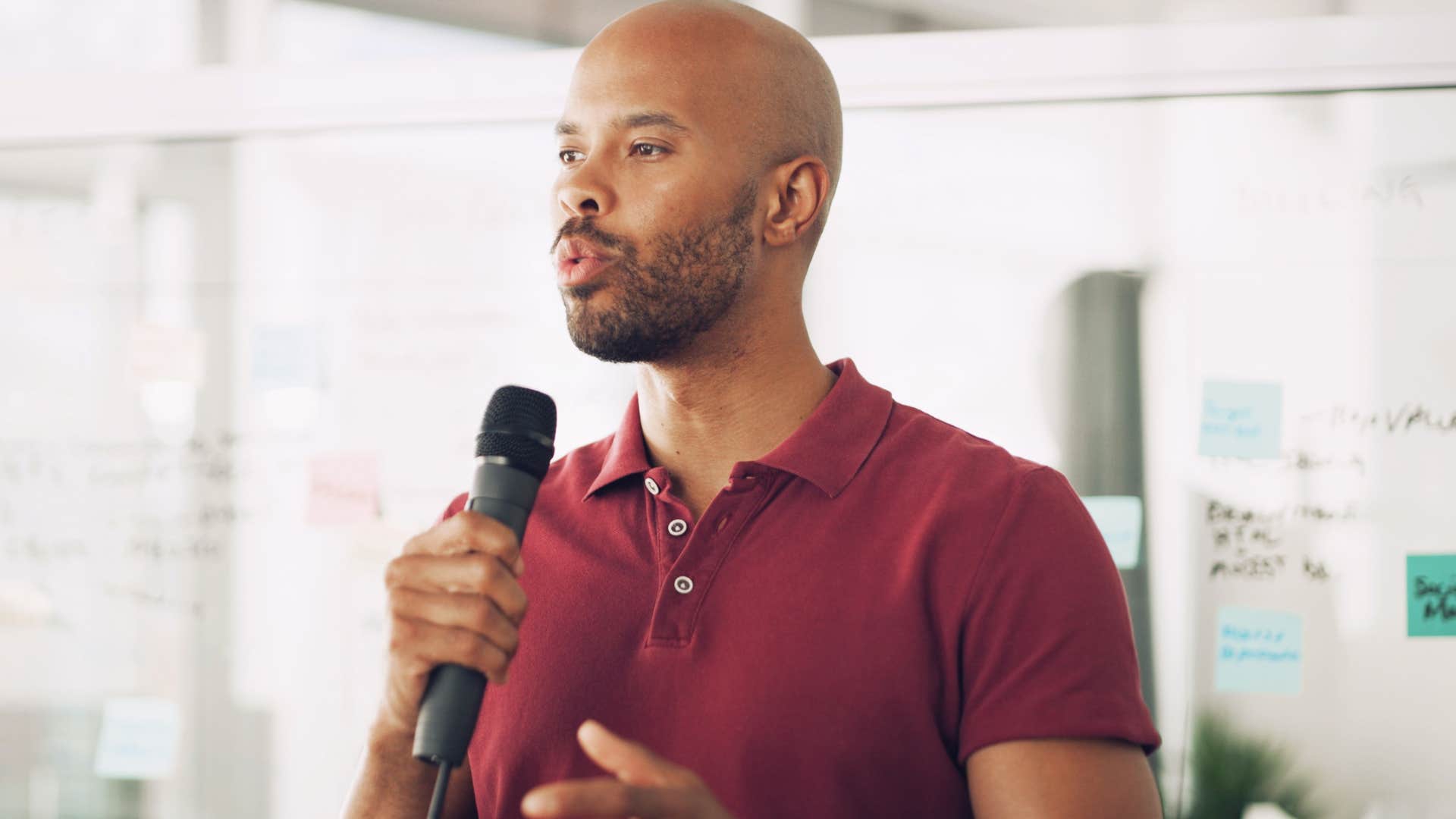 man who's personally attached to work talking into a microphone