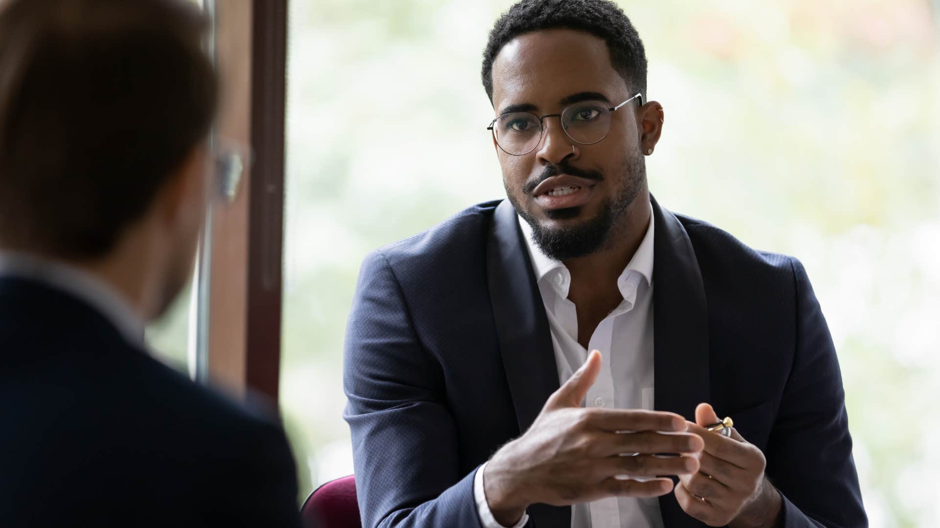 Man getting annoyed by ignorance during a work meeting.