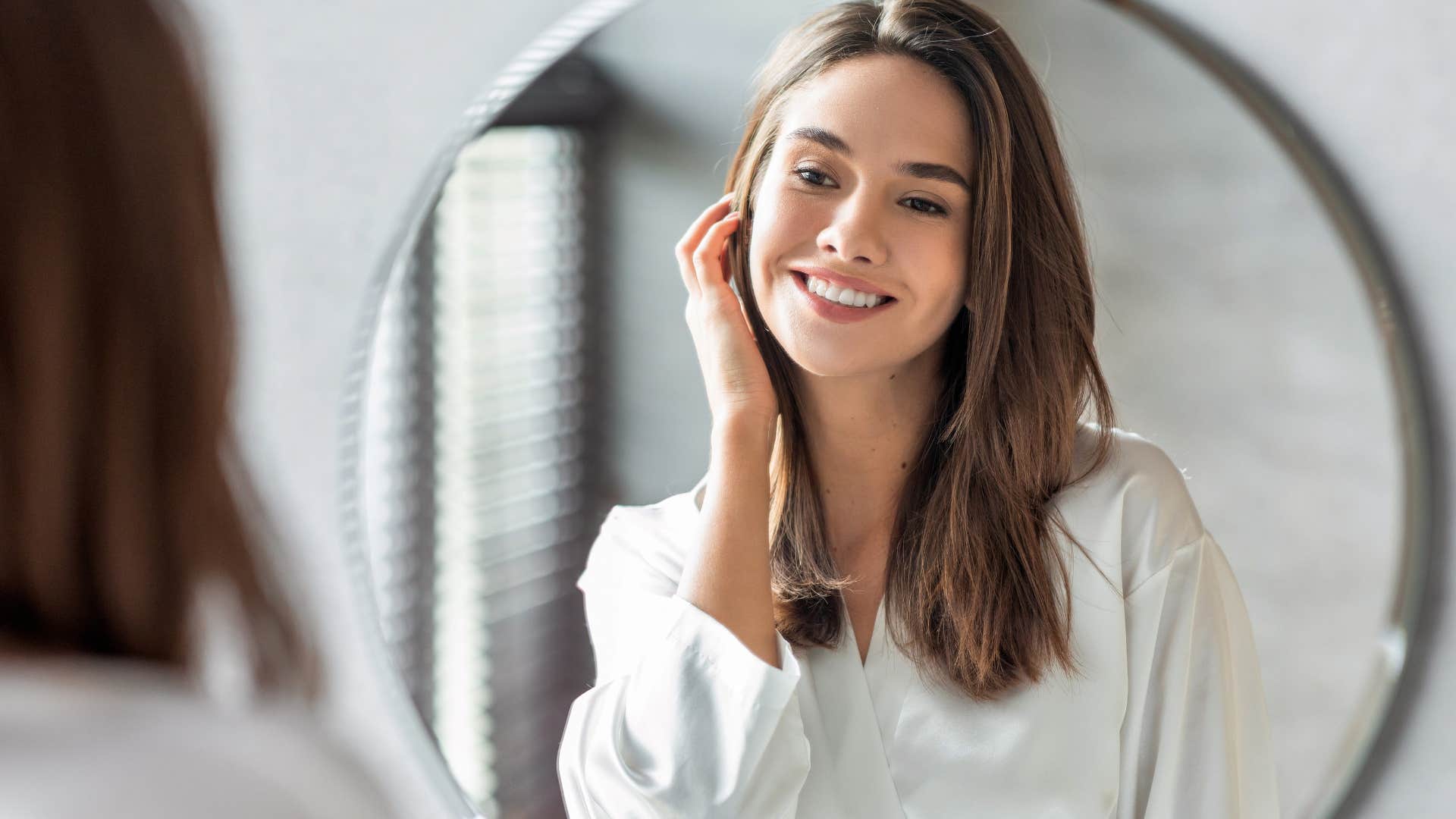 woman looking in mirror after moving it away from the door