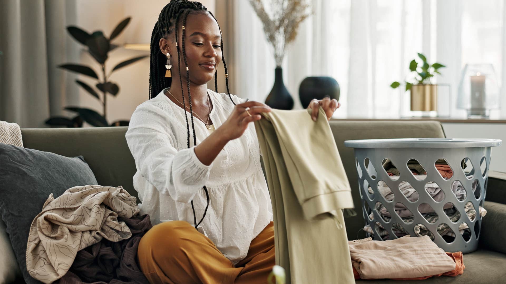 woman folding laundry to remove clutter from entryway of home