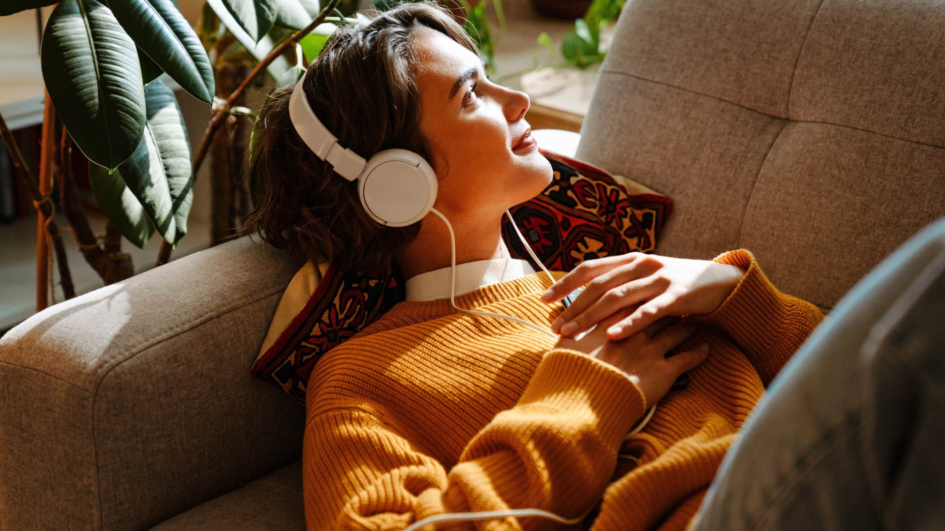 woman looking at wealth symbols in her living room while laying on her couch