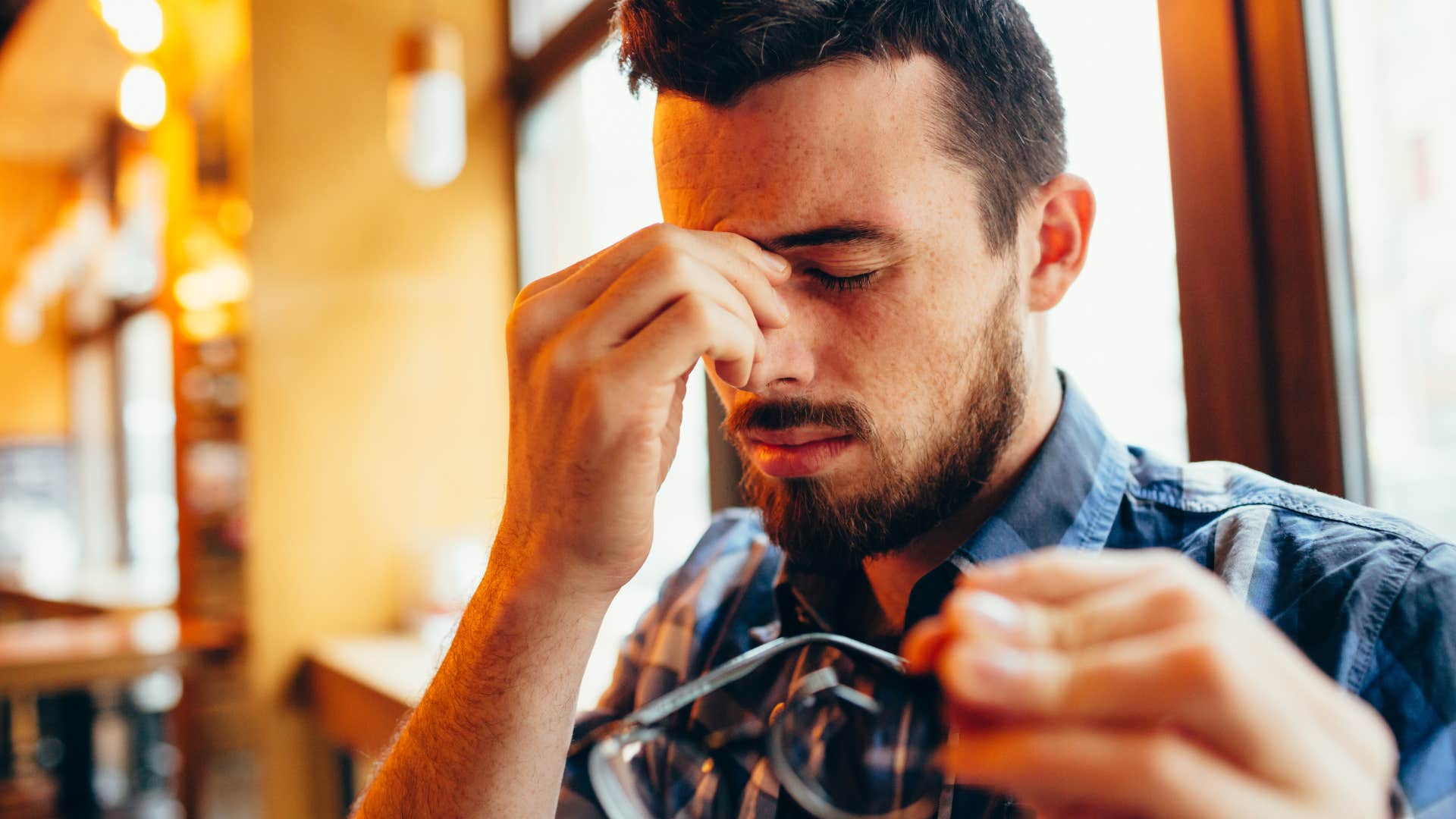 man rubbing the crust from his eyes