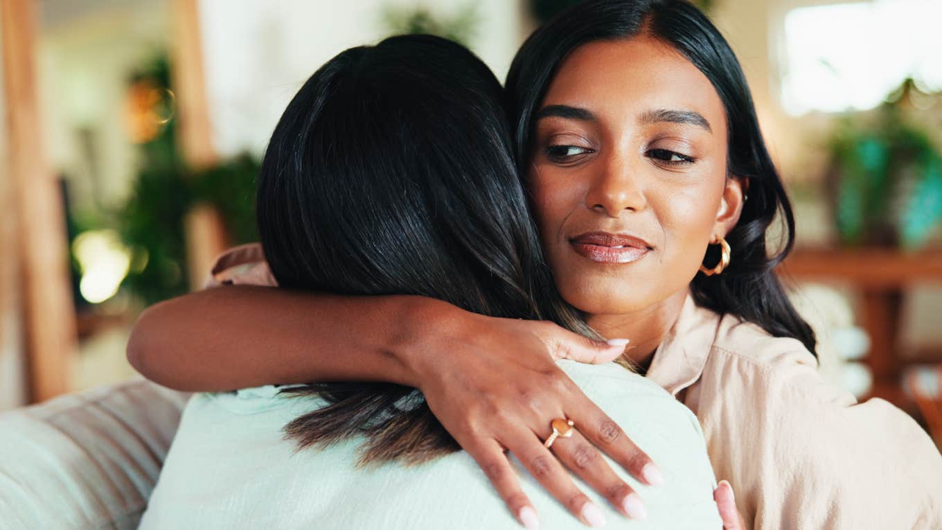 Tiny Ways People Can Tell You Didn’t Shower, Even When You Try To Freshen Up woman hugging friend noticing that she smells bad