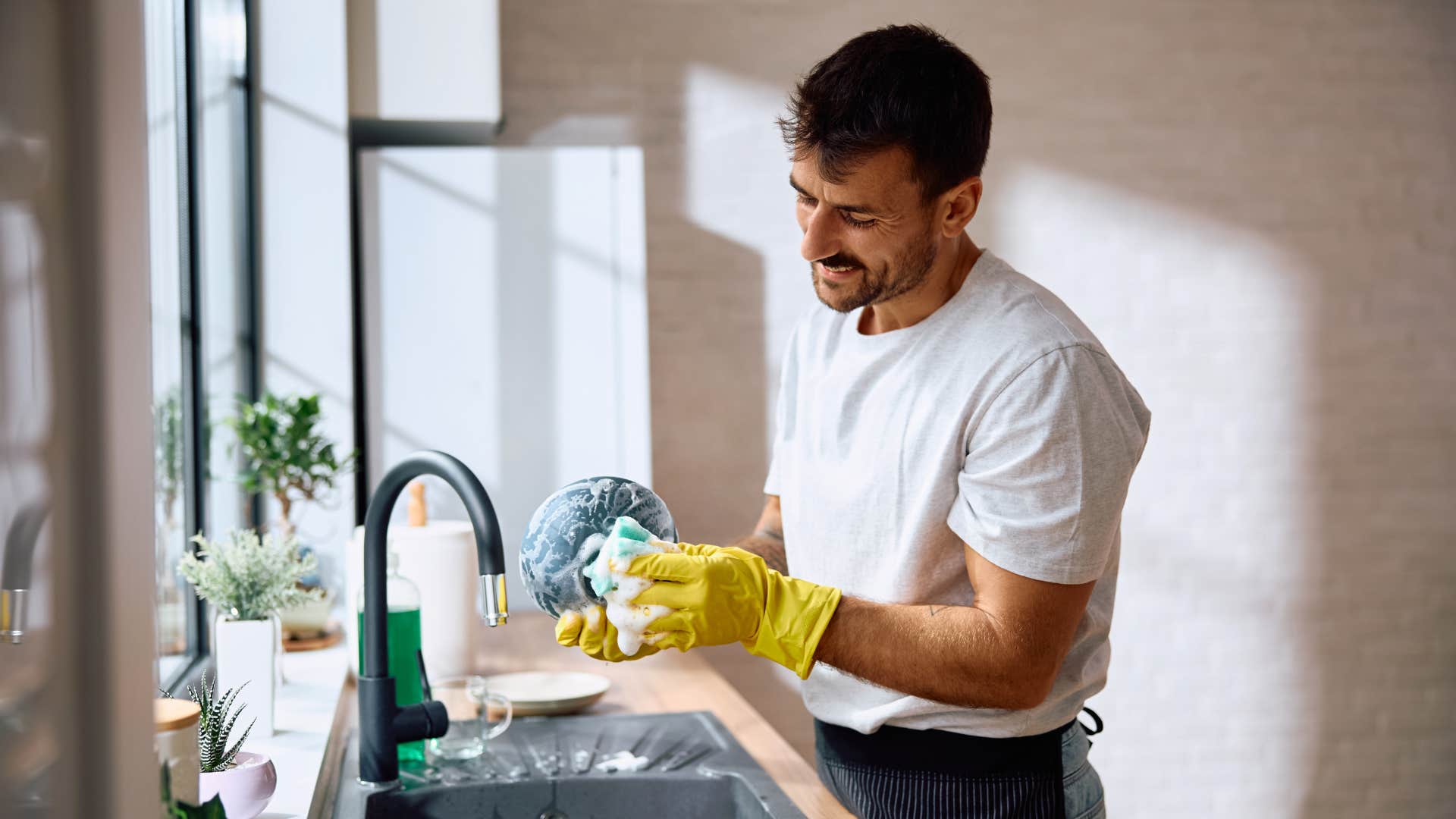 man washing dishes early in the morning