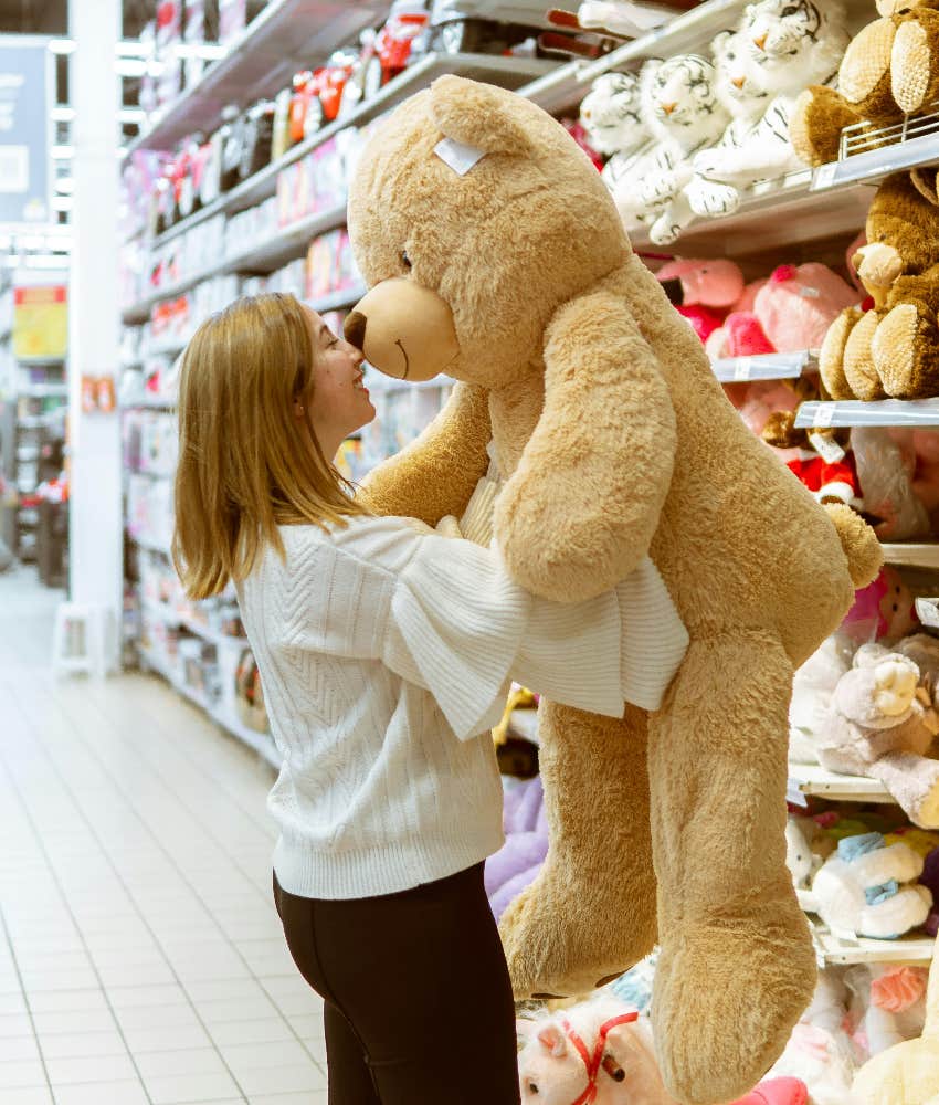 girl picking out a teddy bear at the store