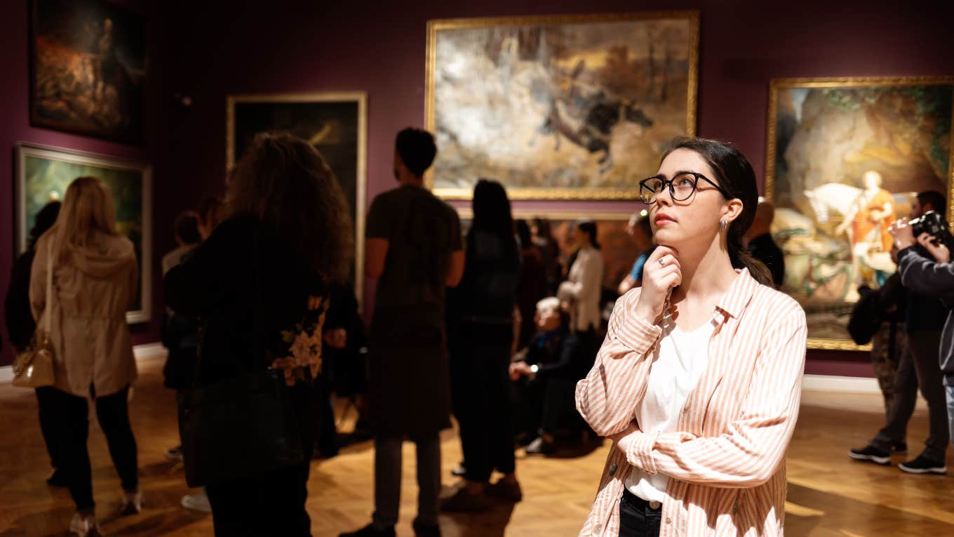 tourist damages painting taking selfie woman looking at art in museum