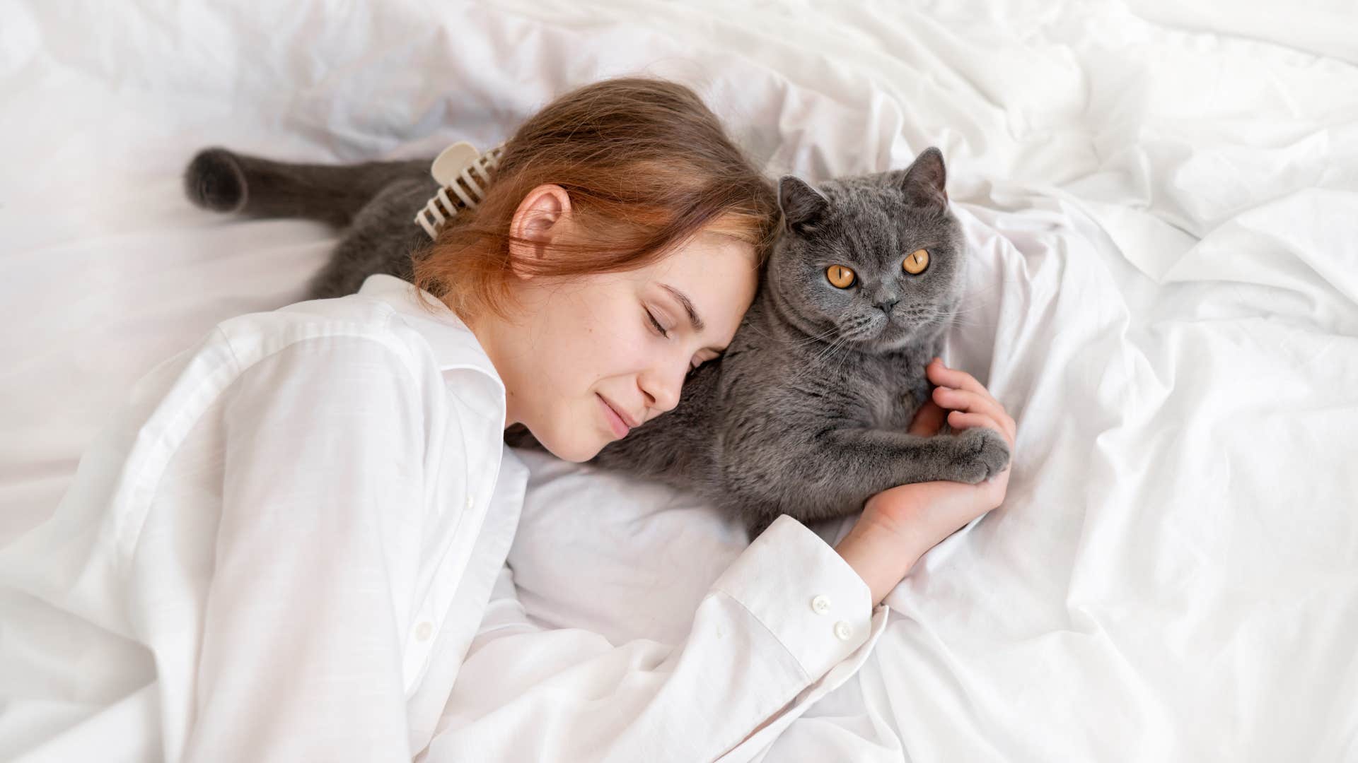 Person cuddles with pet in bad