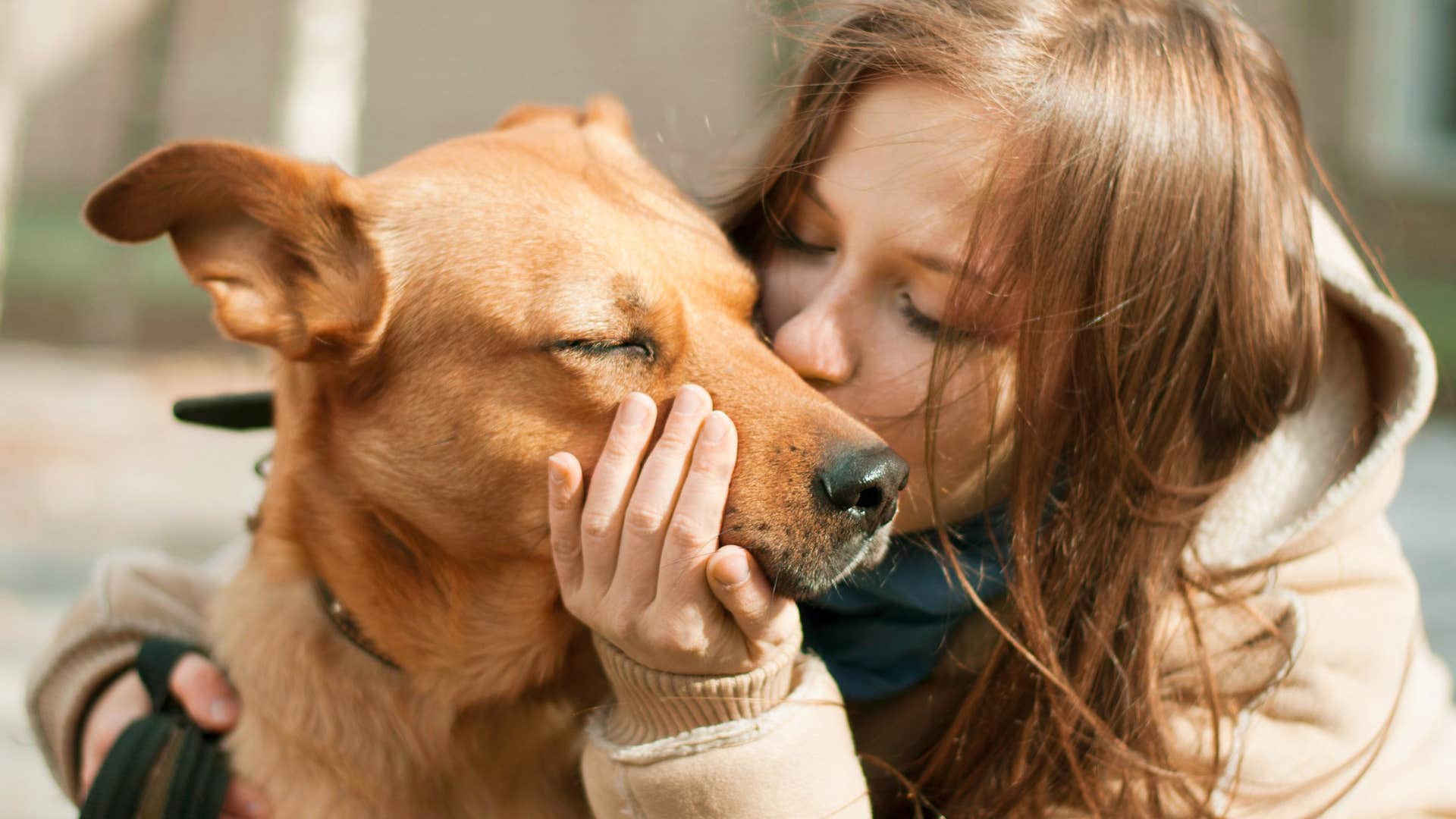 woman kissing her soul dog's face
