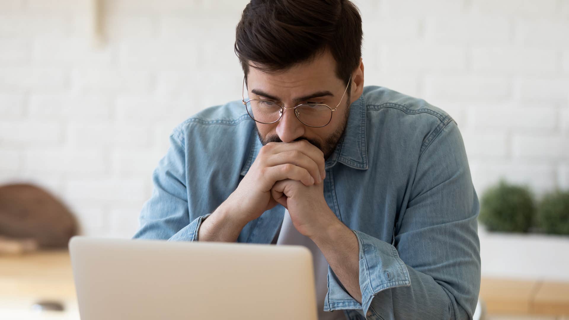 man feeling nervous for other people working on his laptop
