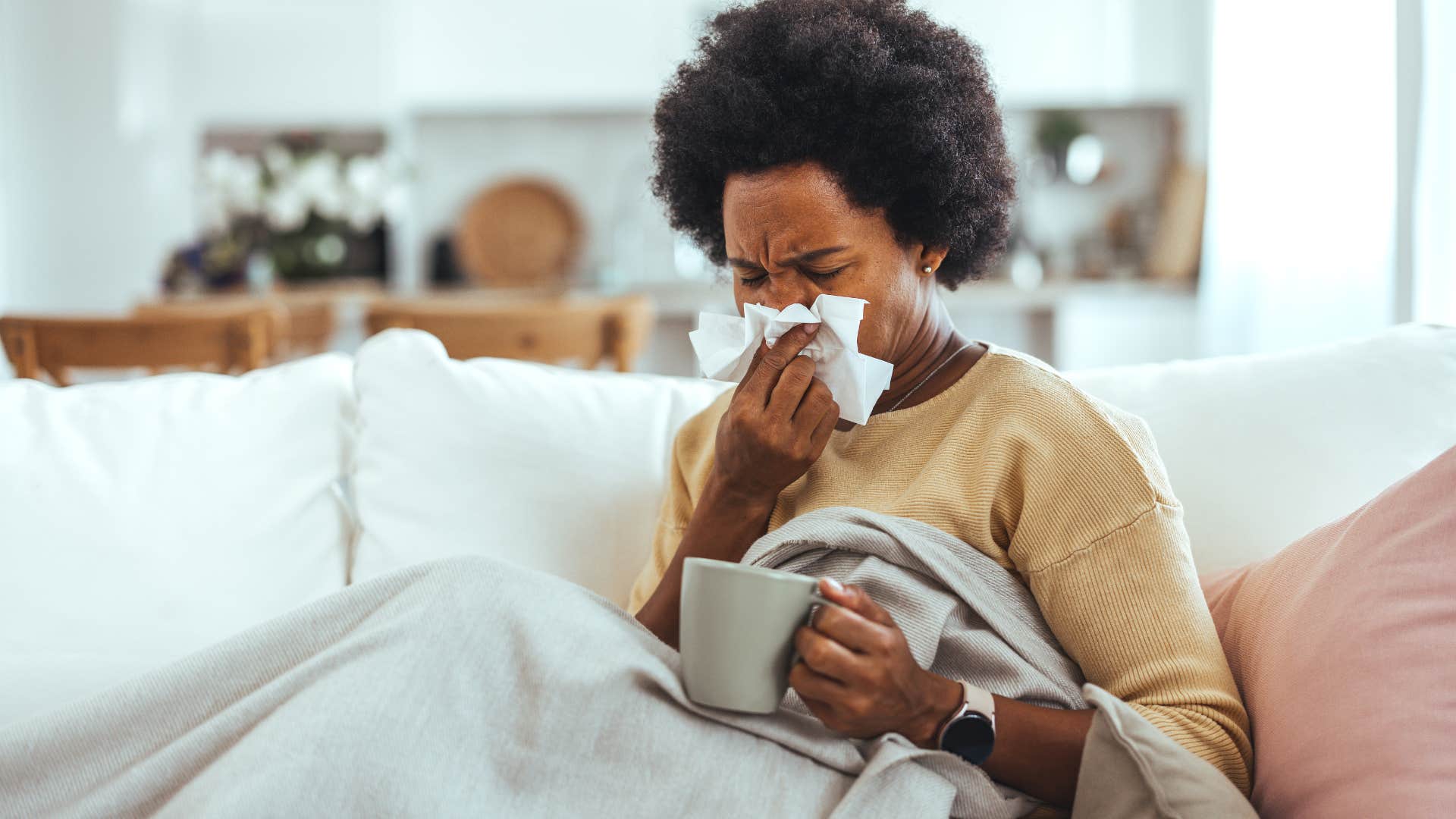 woman fighting off cold on couch
