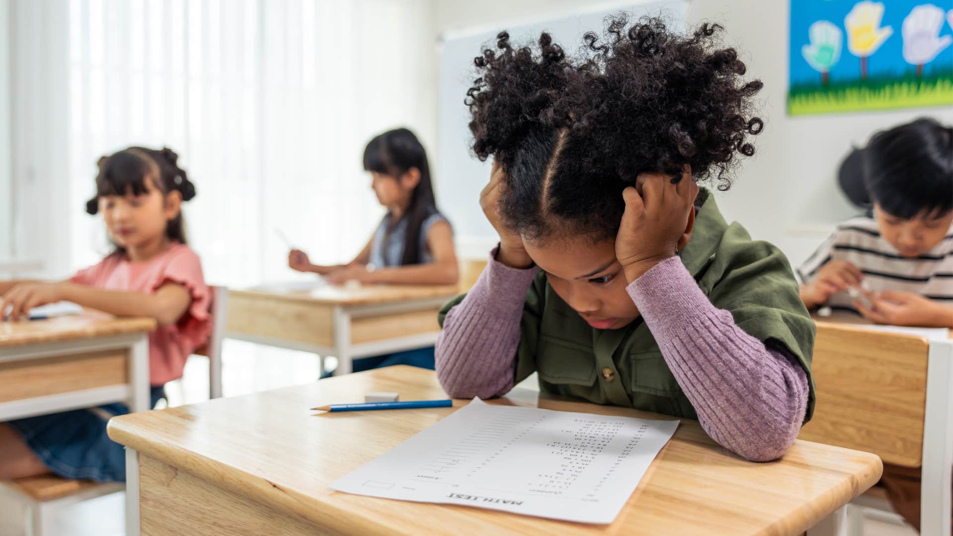 Little girl who views mistakes as failures and holding her head in her hands.