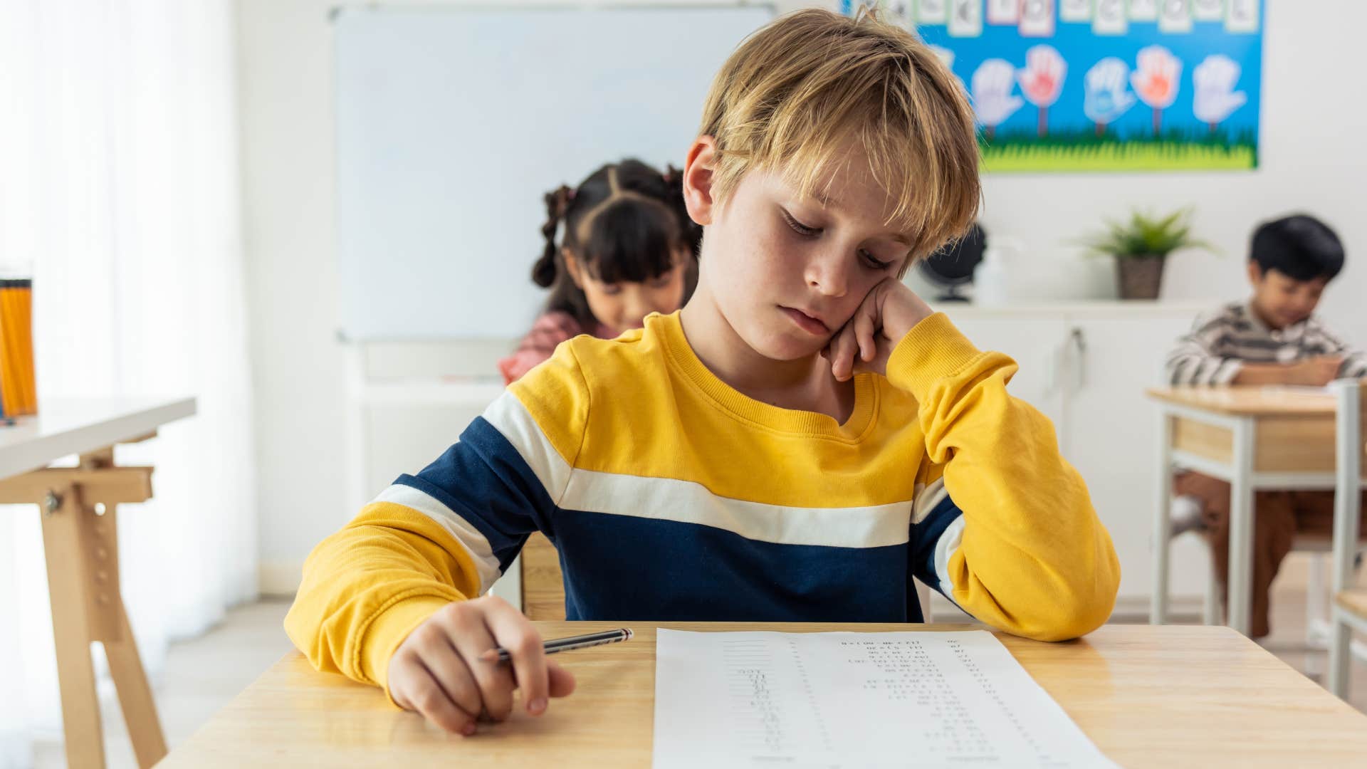 Student who is not motivated looking upset at his desk.